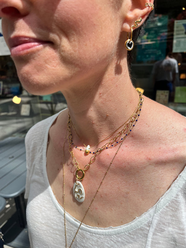 Des pendentifs et boucles d’oreilles en porcelaine illustrée et tatouée d’or pur 