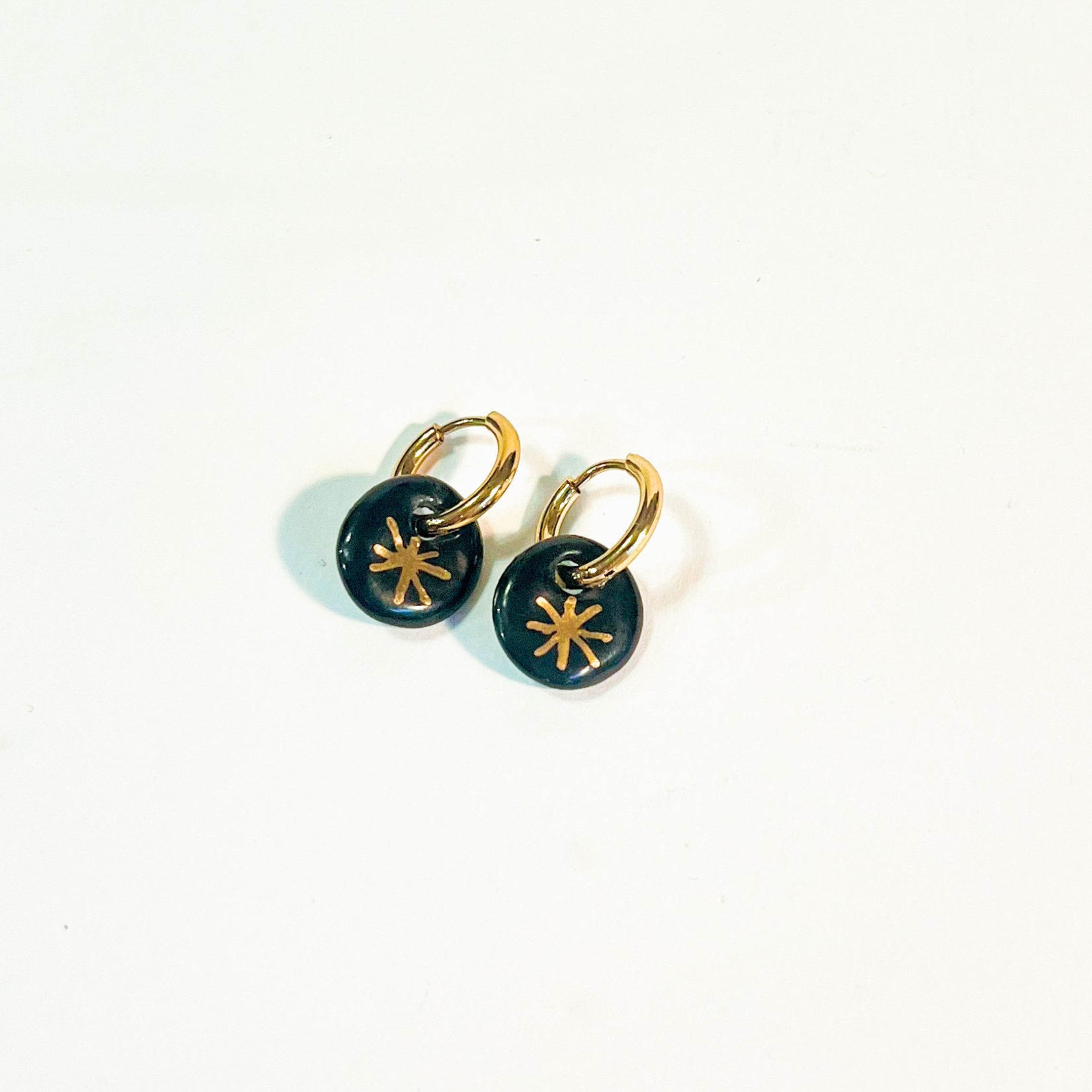 Paire de petites boucles d'oreilles pendantes pour femme en porcelaine noire émaillée avec un motif étoile en or peint à la main