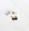 Paire de mini boucles d'oreilles pendantes pour femme. Petits motif ronds en porcelaine noire émaillée ornée d'un cœur or peint à la main.