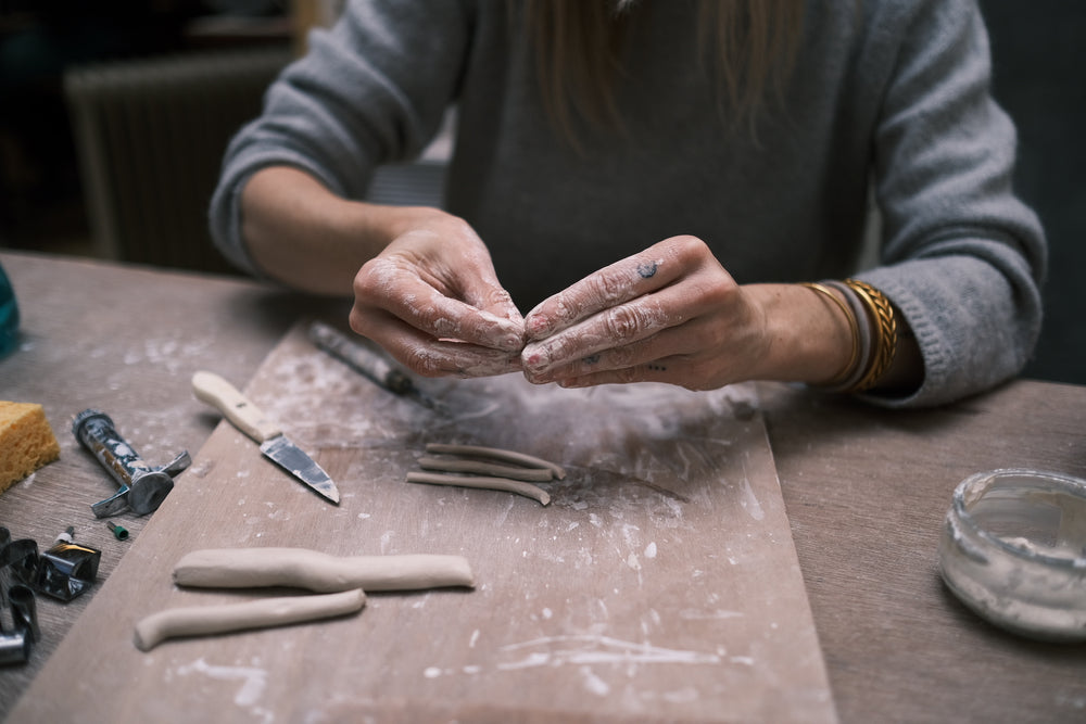 Les mains d’artisane, d’artiste, en plein travail de la terre en céramique 