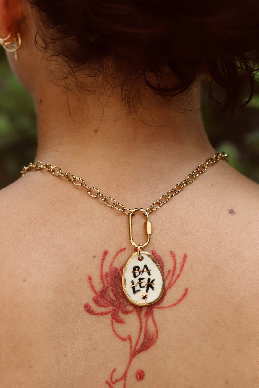 Chaîne en acier avec un pendentif avec le mot balek peint en noir avec des détails en or peint à la main et fabriqué à Lyon 