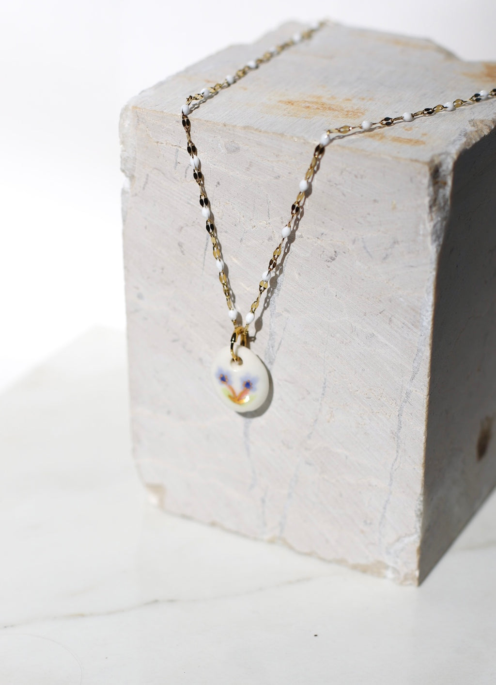 pendentif de collier fabriqué en porcelaine avec un motif floral peint à la main 