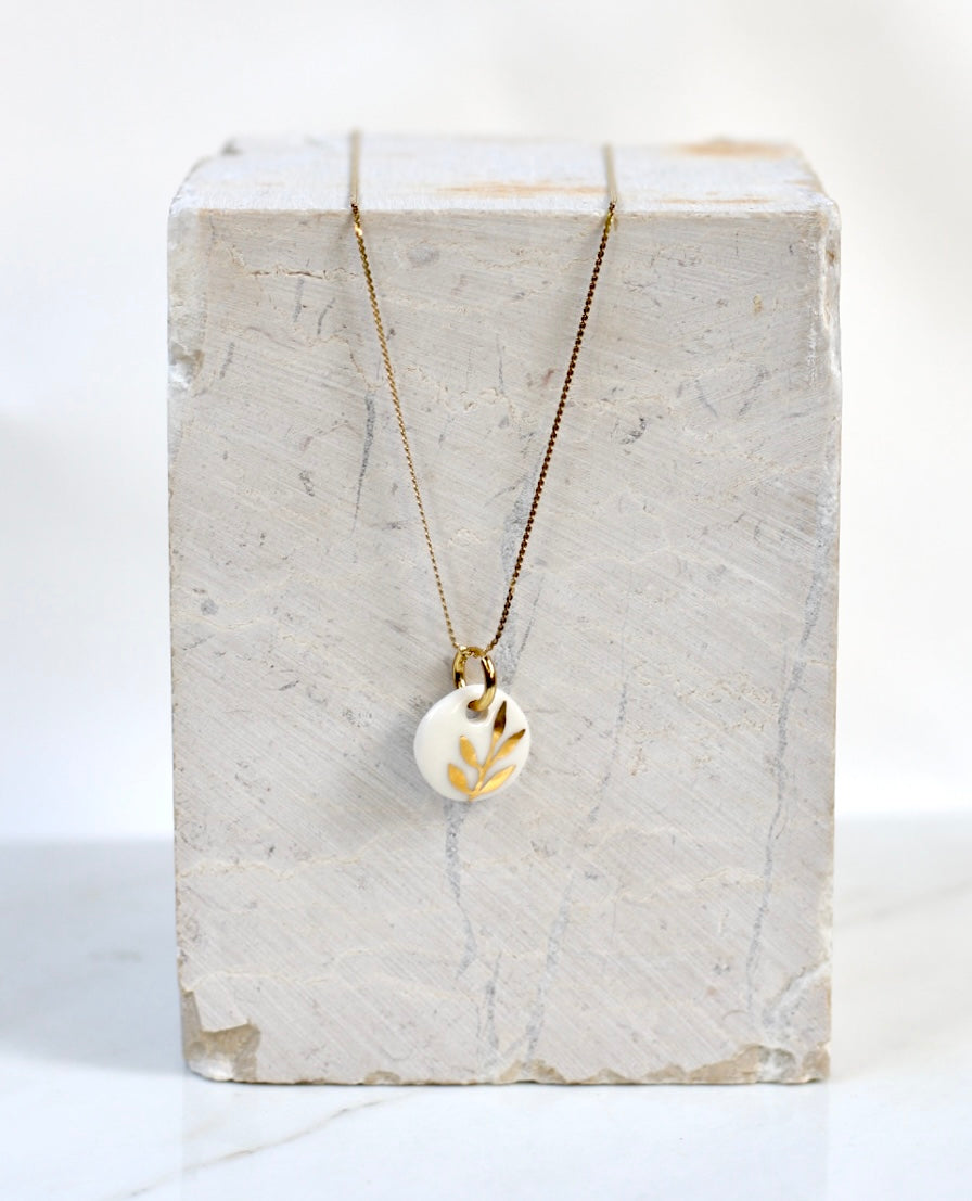 pendentif en porcelaine blanc avec un motif floral peint à la main à l'or liquide à Lyon 
