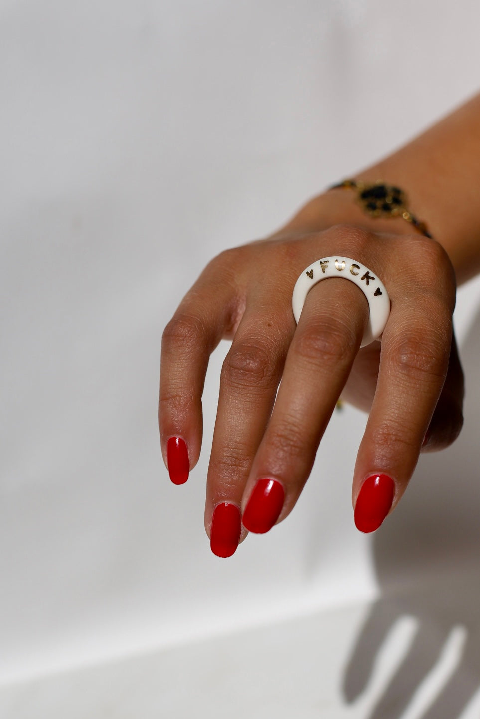 bague mince en porcelaine blanche émaillée taille 55 FR, avec l'inscription 'FUCK' et des détails à l'or peint à la main 