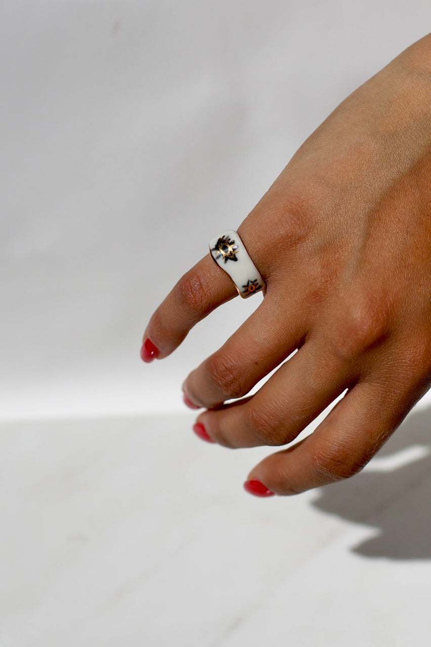 Bague asymétrique en céramique fait main avec un motif d'oeil peint à la main en noir et or liquide. Taille 49 FR