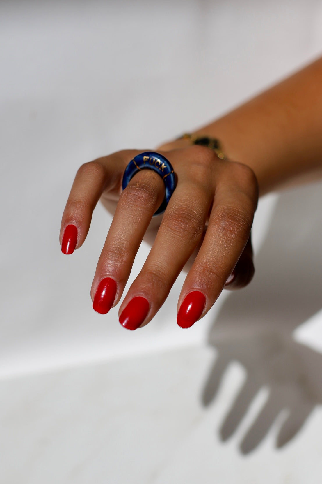 bague en porcelaine émaillée bleu nuit intense en taille 52 FR, avec fuck écrit en lettrage or peint à la main 