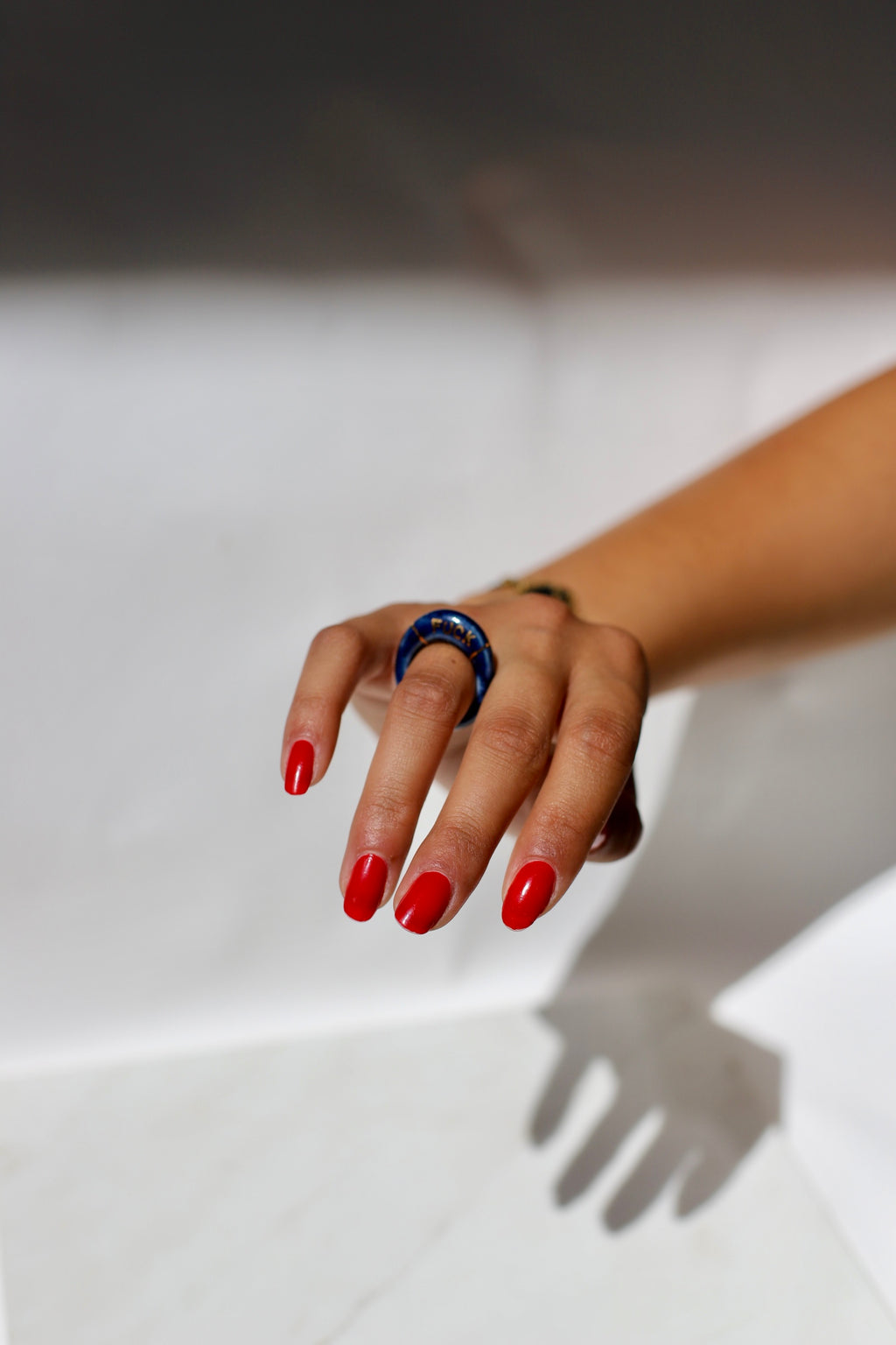 bague en porcelaine émaillée bleu nuit intense en taille 52 FR, avec fuck écrit en lettrage or peint à la main 