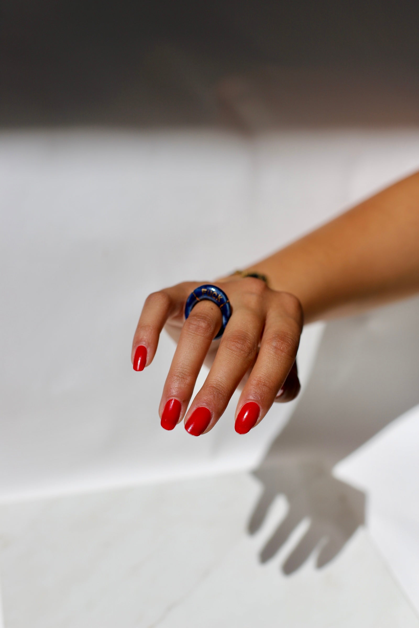 bague en porcelaine émaillée bleu nuit intense en taille 52 FR, avec fuck écrit en lettrage or peint à la main 