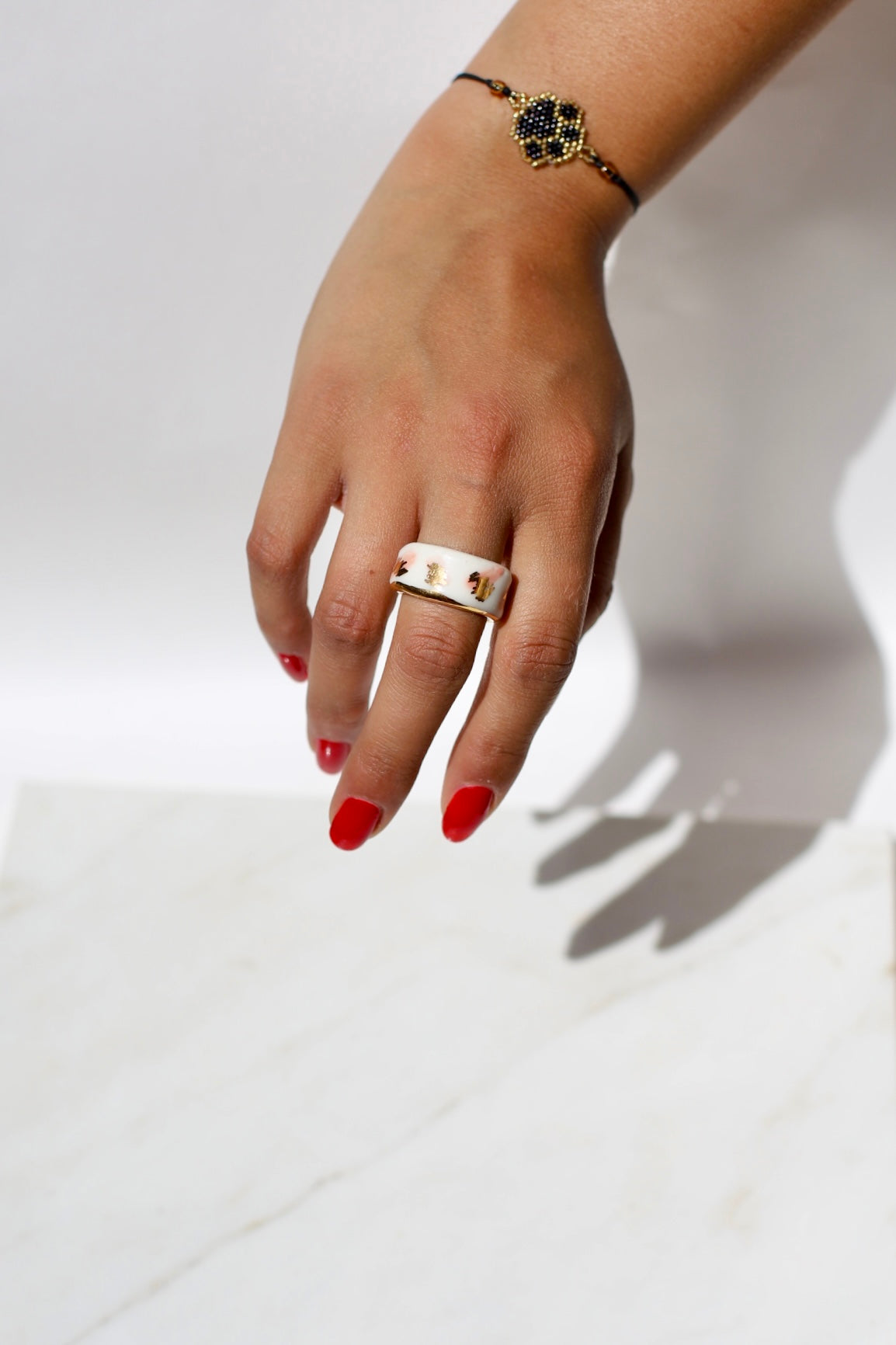 Bague blanche en porcelaine avec des détails peint à la main en couleur rose et or liquide. Bague taille FR 52 