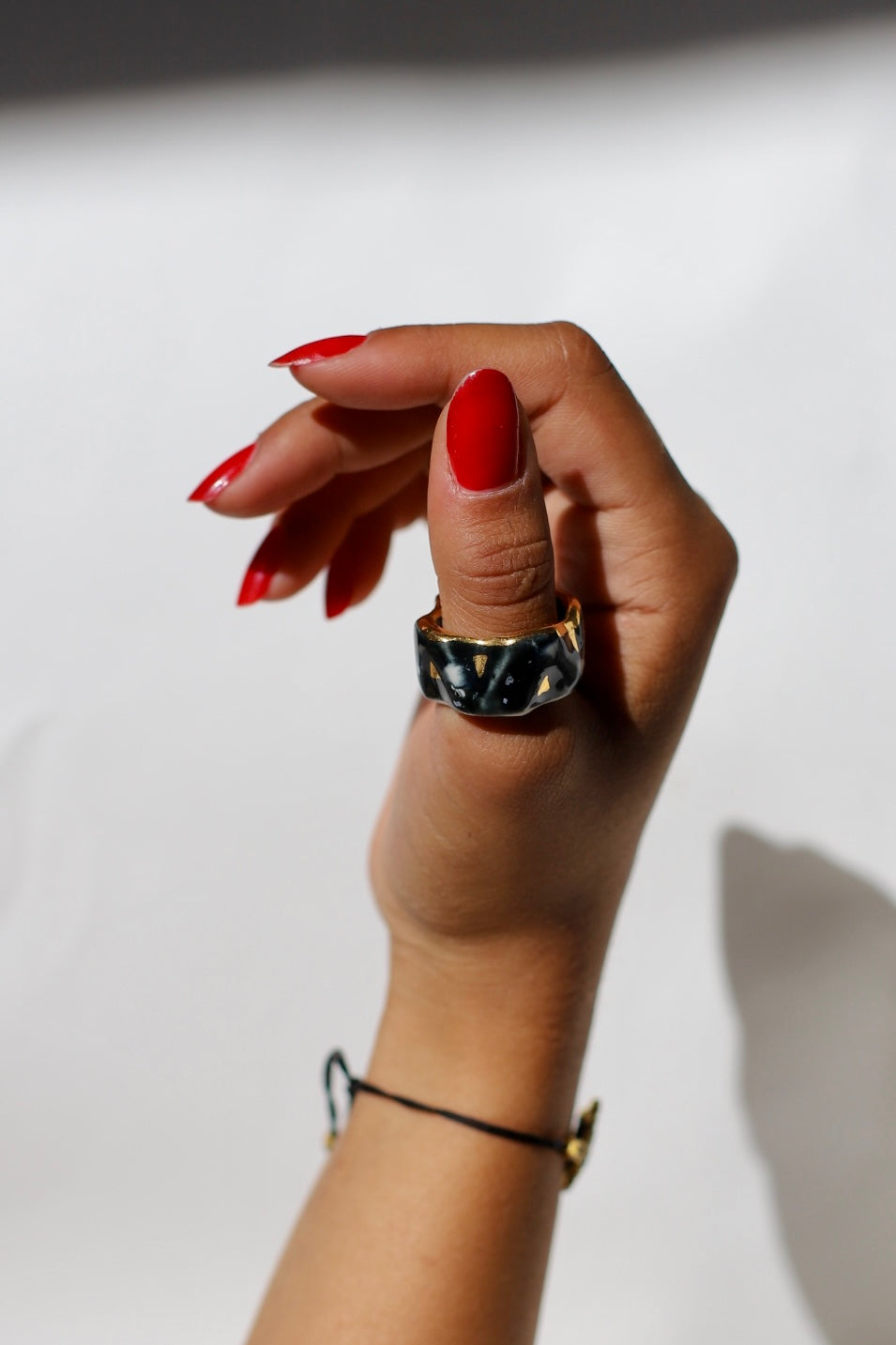 anneau sculptural en porcelaine noire taille 60 FR, avec des triangles en or. Bague effet marbre taille 60 FR