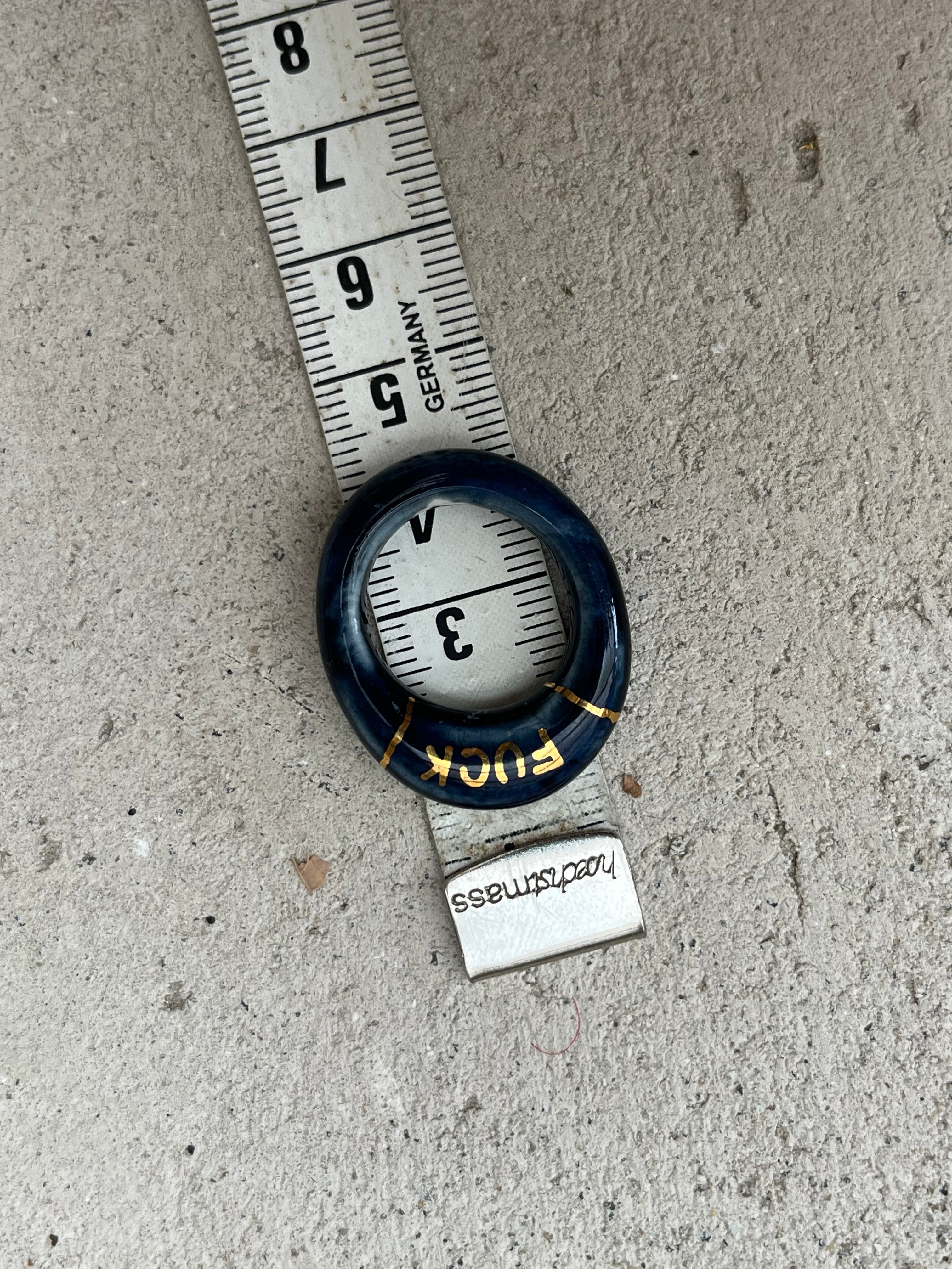 bague en porcelaine émaillée bleu nuit intense en taille 52 FR, avec fuck écrit en lettrage or peint à la main 