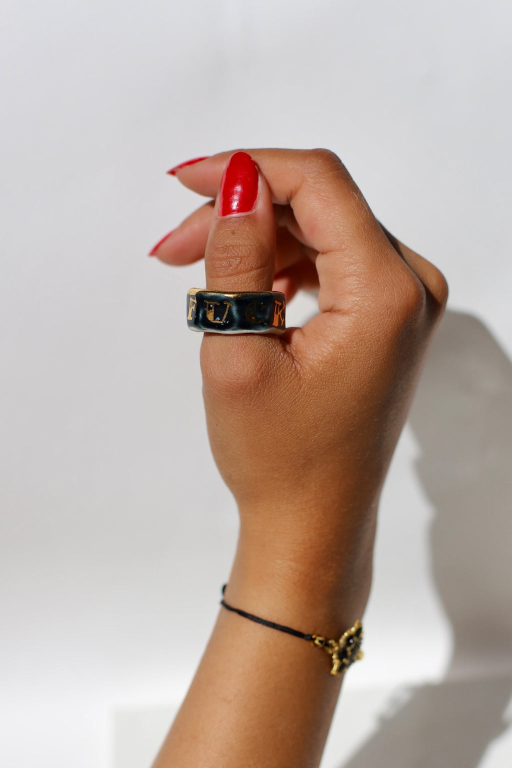 Bague noir en porcelaine fait main teinté dans la masse avec inscription du mot fuck peint à l'or en taille 60 FR 