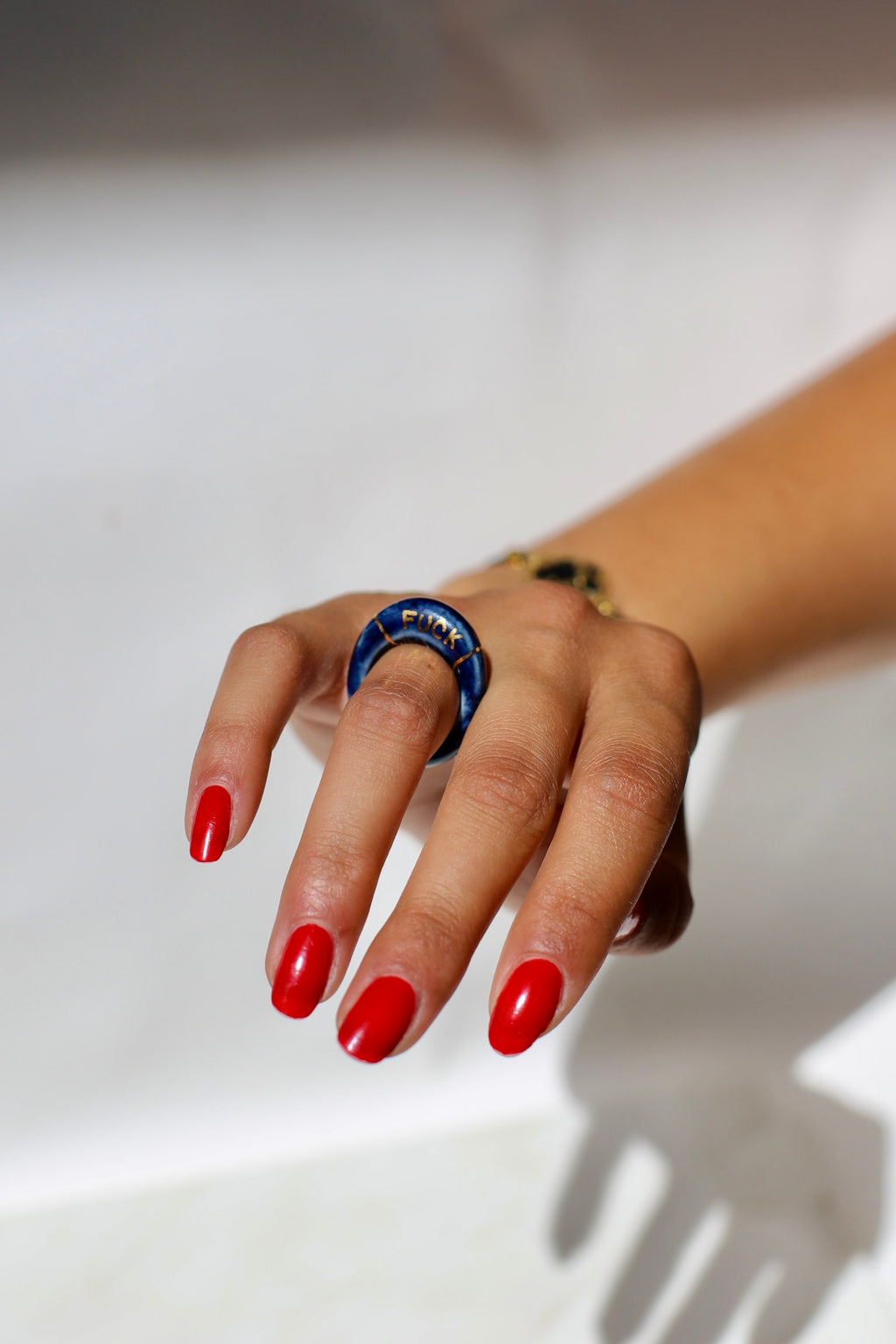 bague en porcelaine émaillée bleu nuit intense en taille 52 FR, avec fuck écrit en lettrage or peint à la main 
