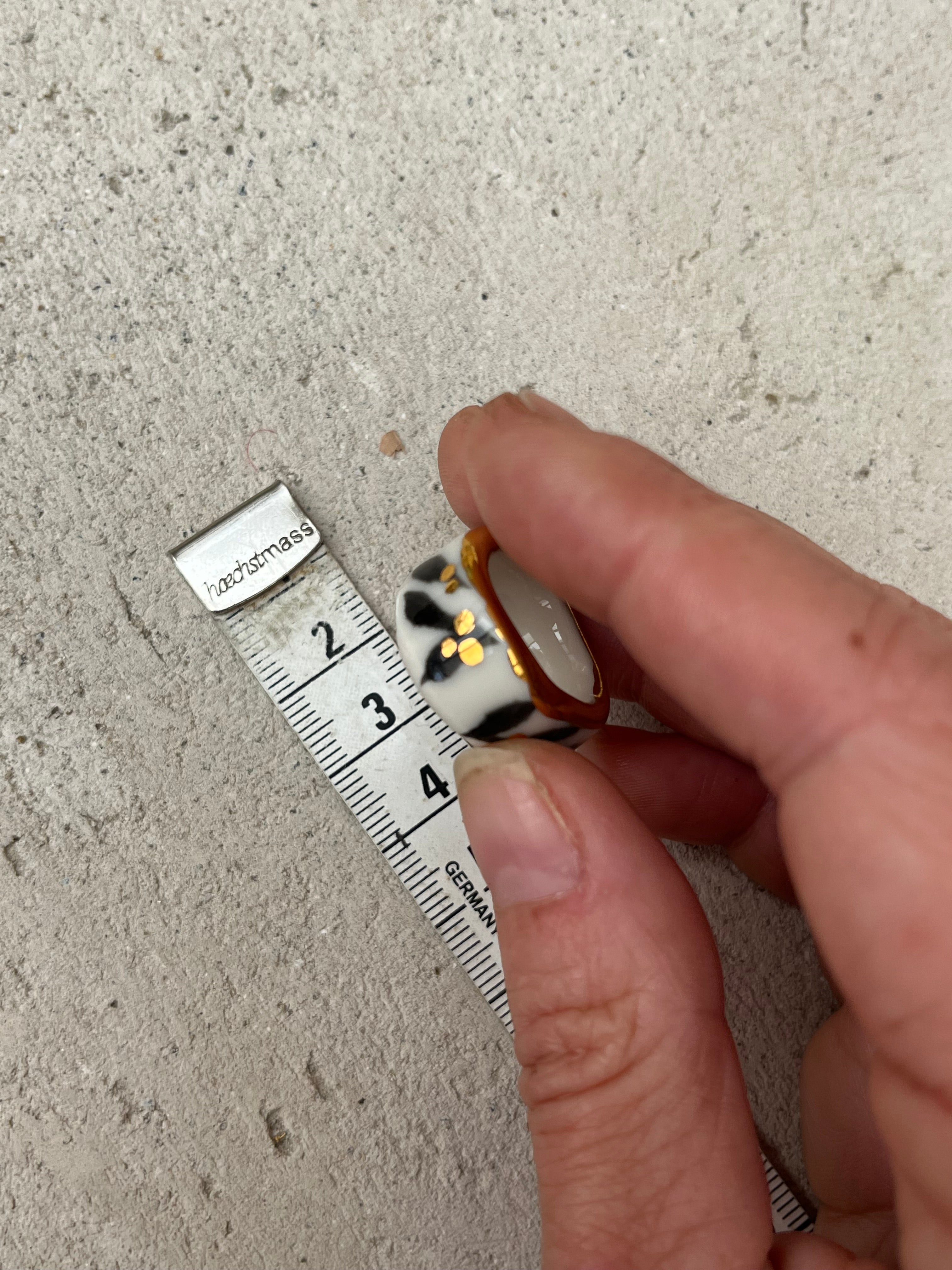bague en porcelaine blanche en taille 50 Fr, à motif floral peint à la main de couleur noir avec des touches d'or avec un liseré d'or 