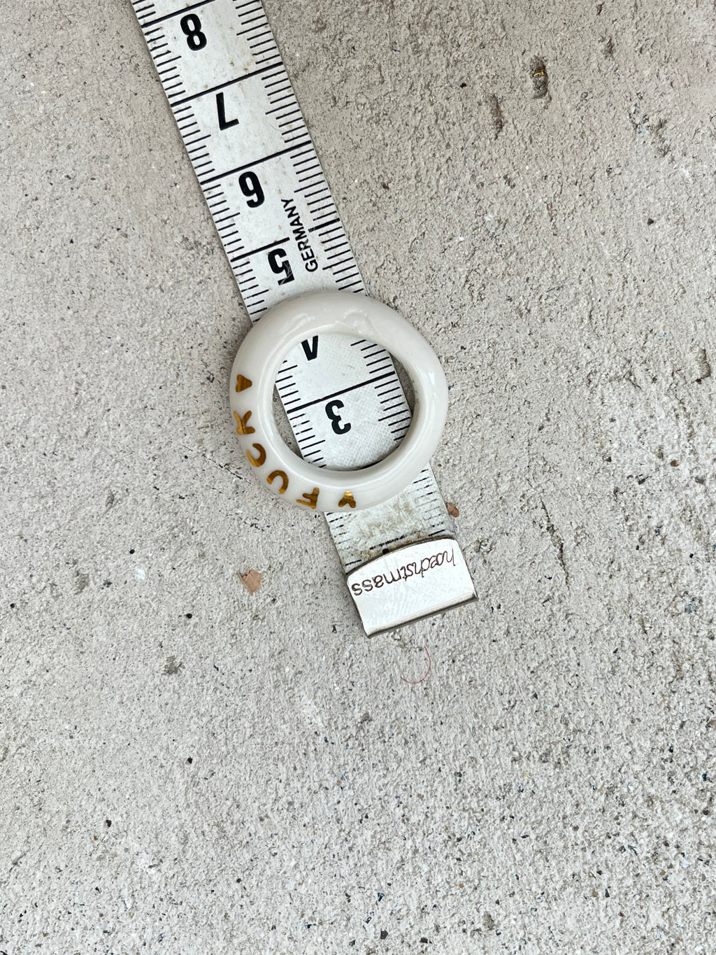 bague en porcelaine blanche émaillée en taille 55 FR, avec le mot 'LOVE' inscrit en lettres fines d'or peint à la main.