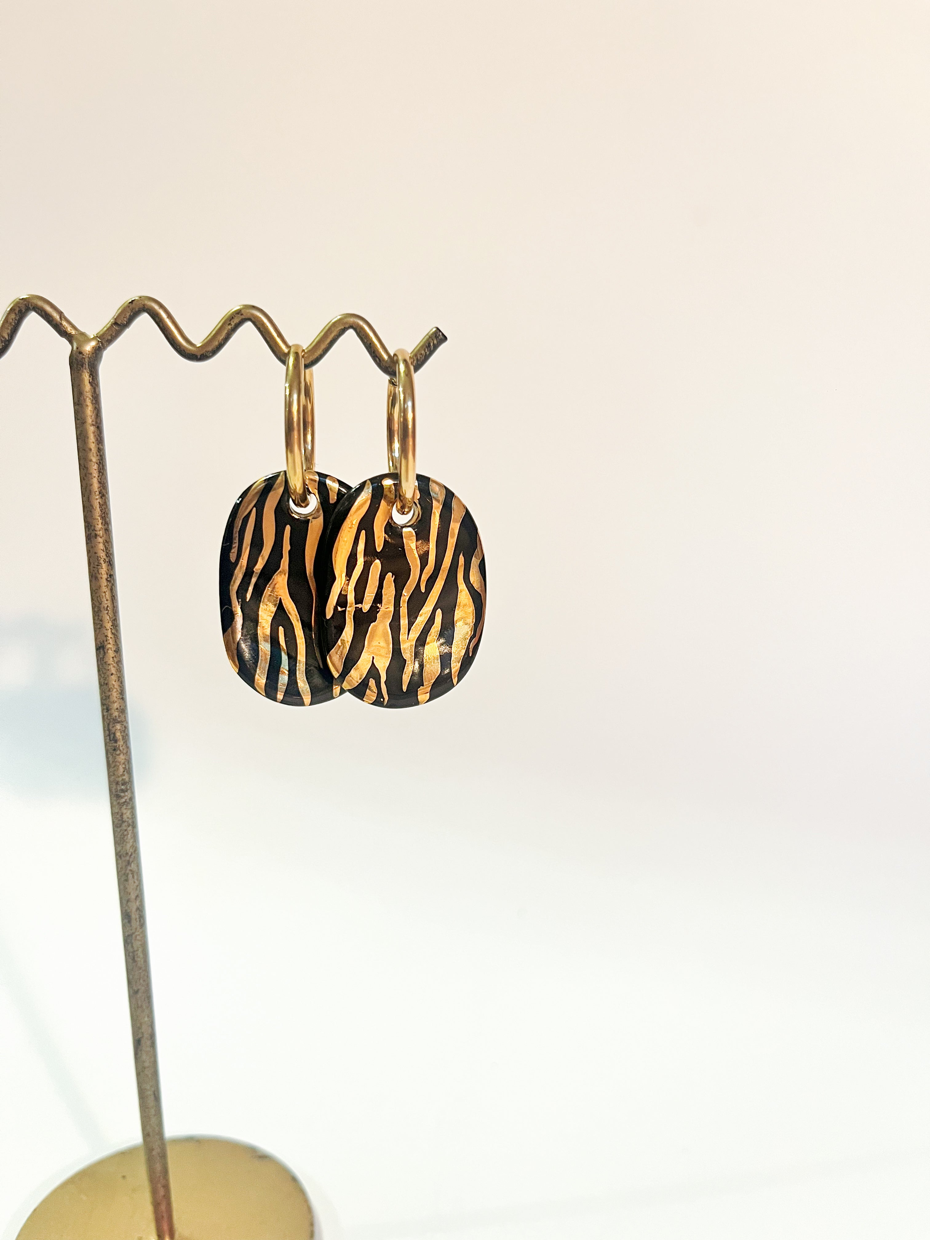 boucle d'oreille  doré portant un motif zébré à l'or