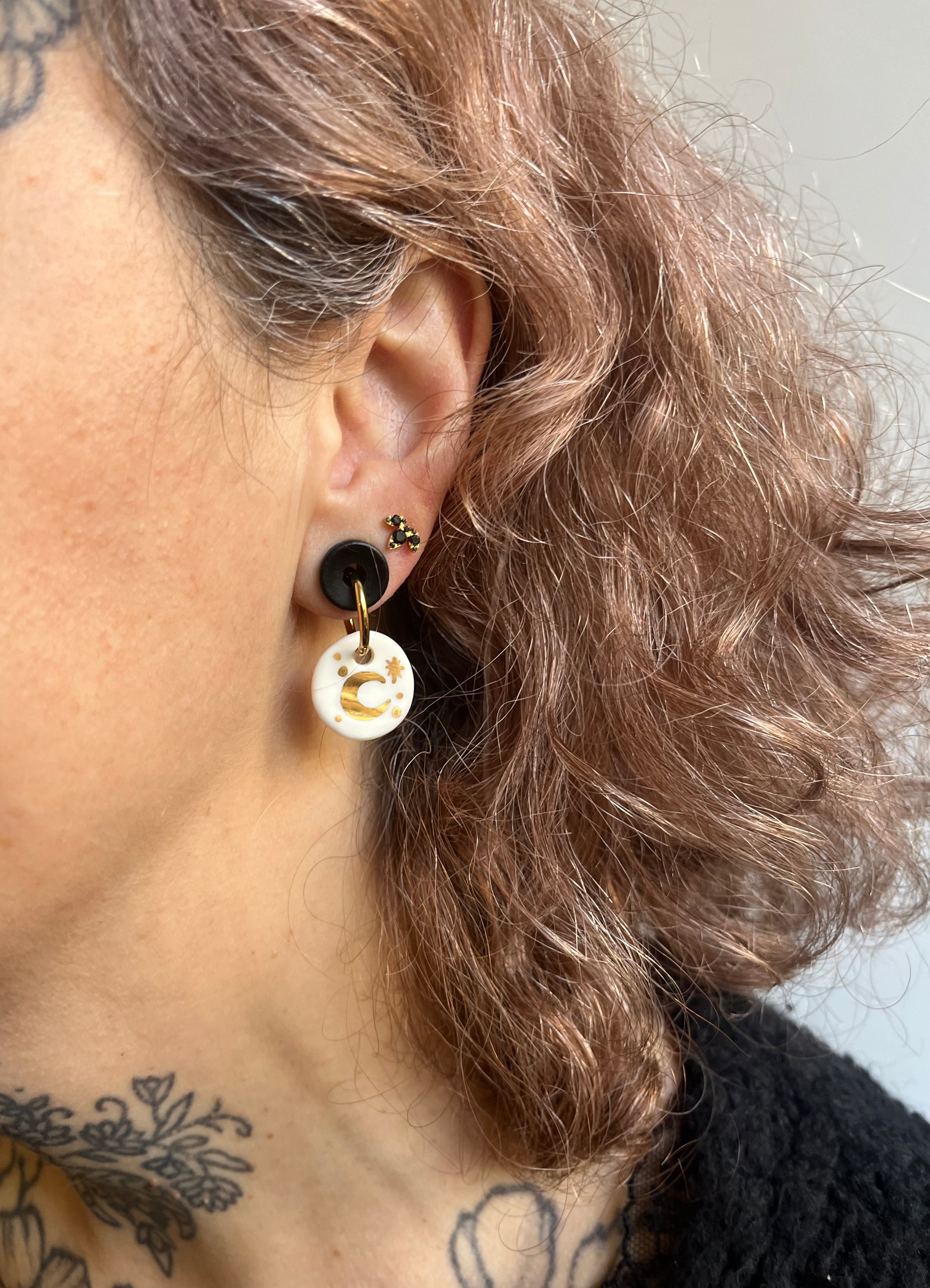 boucle d'oreille pendante dorée faite en porcelaine blanche à la main avec un motif de croissant de lune brillant peint à l'or. Fait à la main à Lyon 