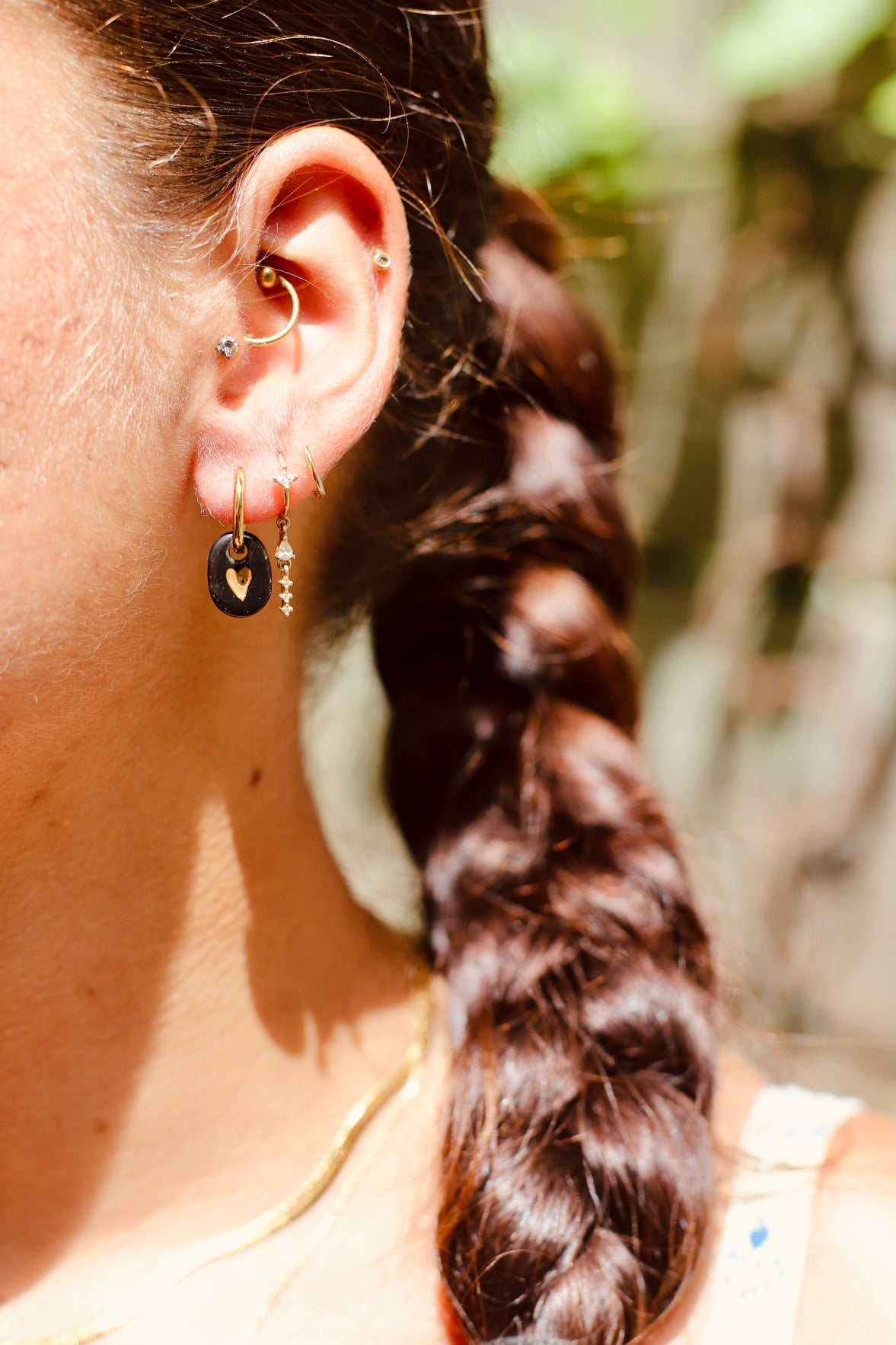boucle d'oreille pendante noir en porcelaine faites à la main avec un motif coeur dessinée à l'or liquide.