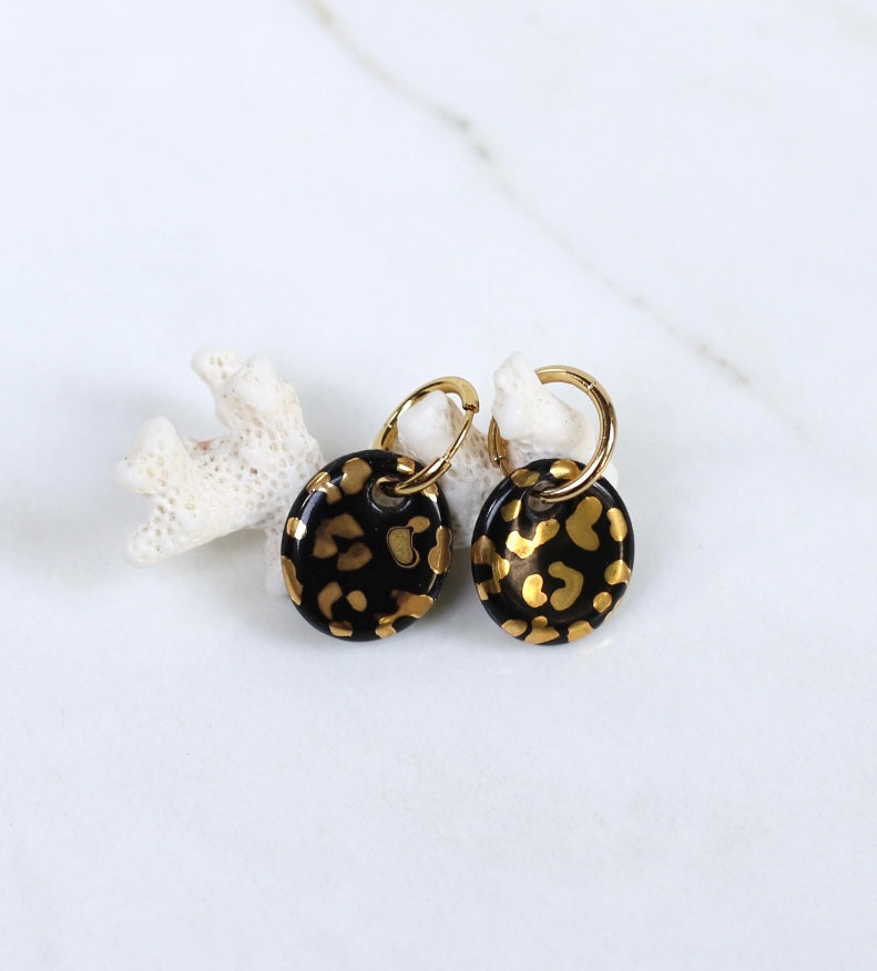 boucle d'oreille pendante dorée en porcelaine noire au motif léopard doré brillant fait à Lyon. 