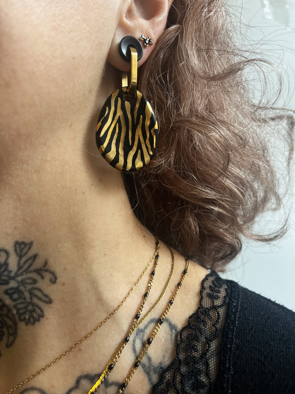 boucle d'oreille pendante noir en  porcelaine noire avec un motif de rayures zébrées à l'or liquide fais main 