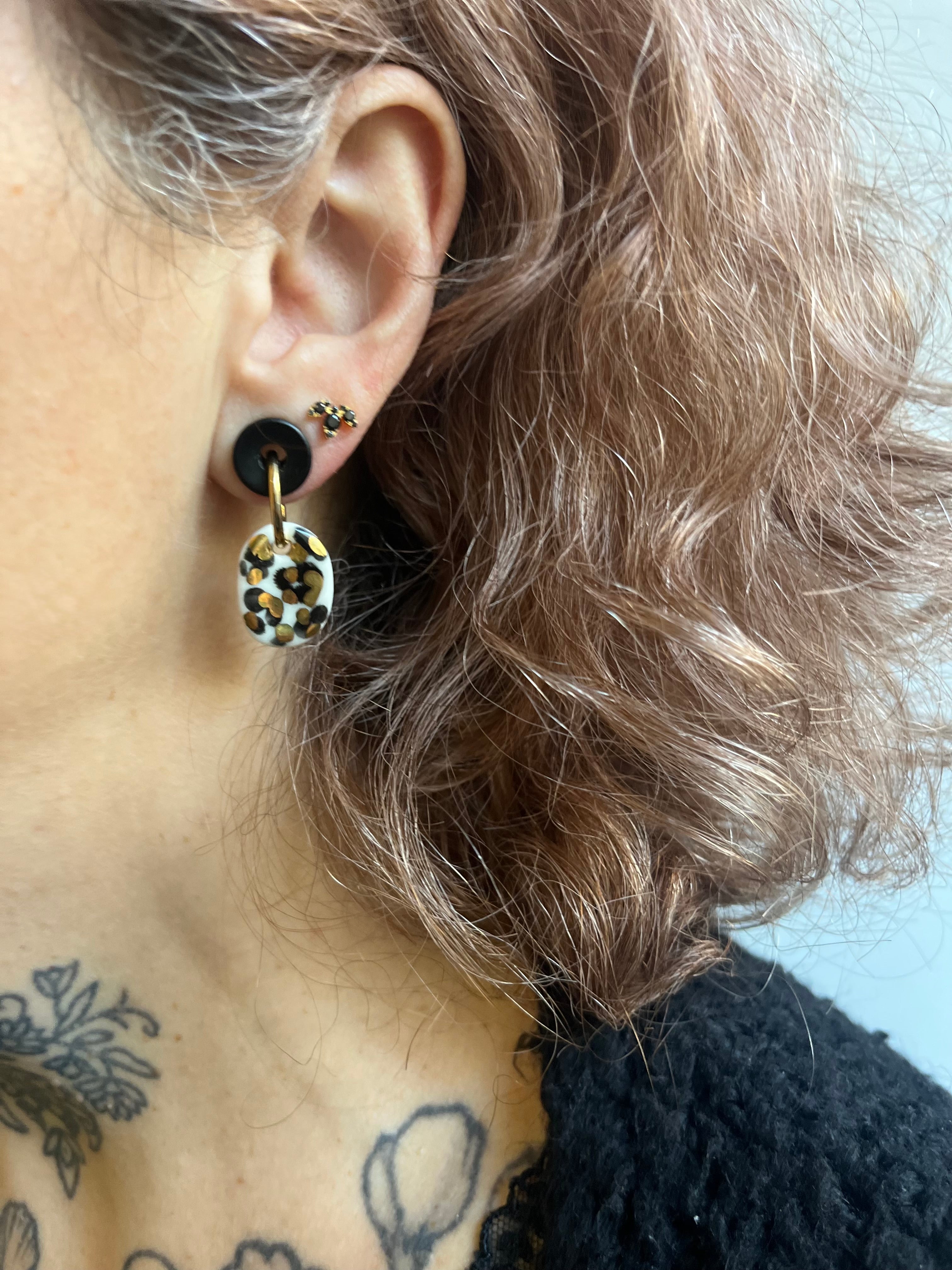 Boucle d'oreille de créateur fais main en céramique avec des motifs en or 
