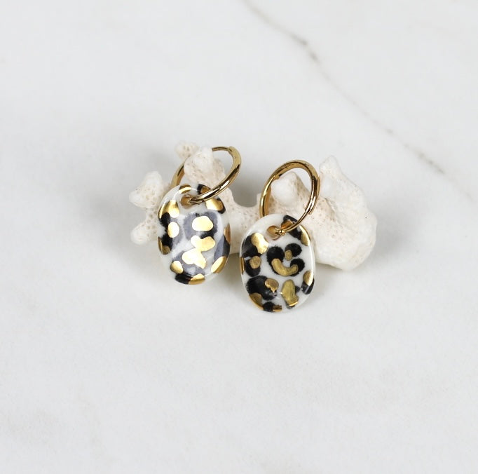 boucle d'oreille en porcelaine blanc à motif léopard avec des touches d'or 