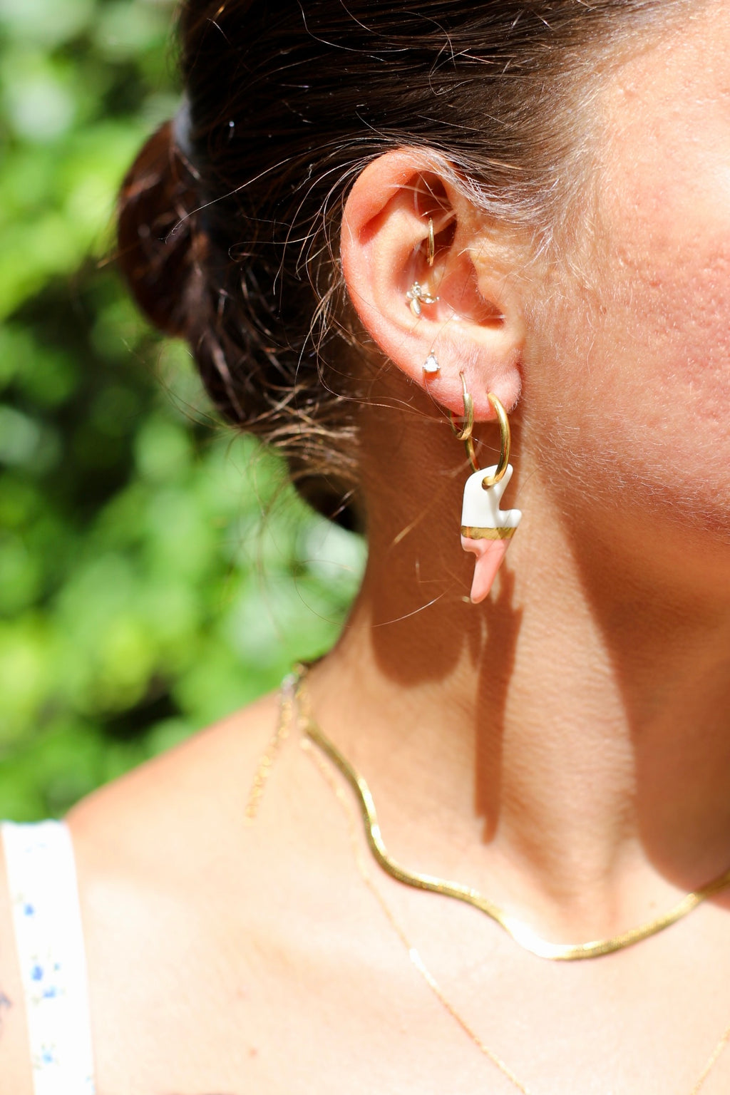 Boucle d'oreille dorée avec un pendentif en forme d'éclair bicolore blanc et rose saumon, avec une touche d'or réalisé à la main.