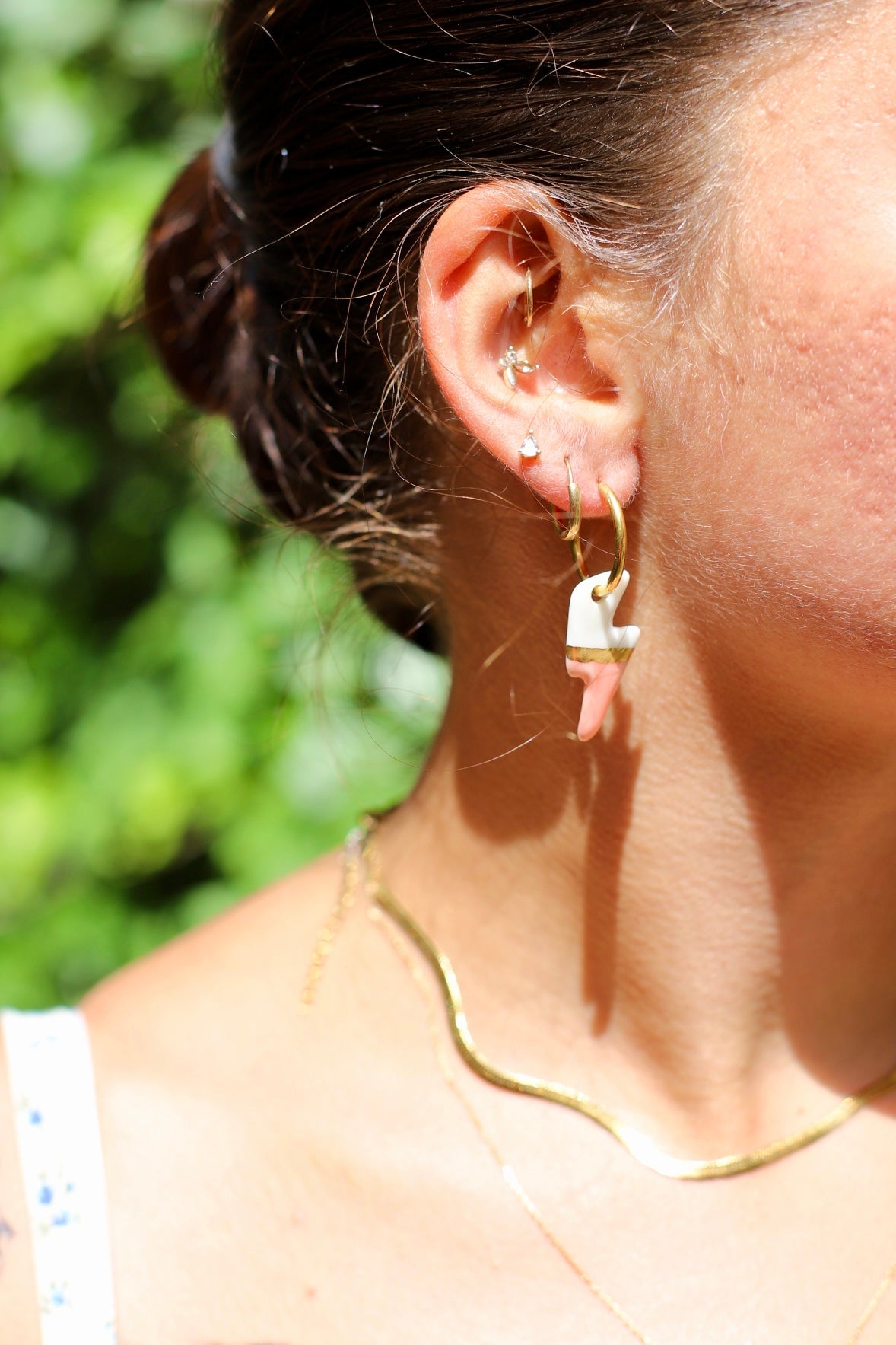 Boucle d'oreille dorée avec un pendentif en forme d'éclair bicolore blanc et rose saumon, avec une touche d'or réalisé à la main.