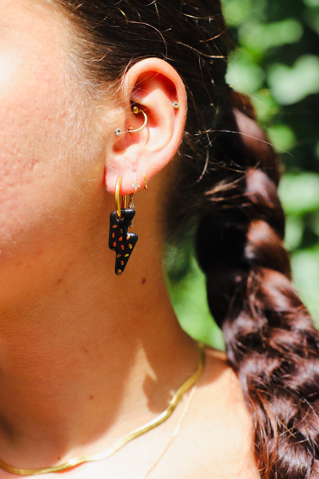 boucle d'oreille noir avec un pendentif en forme d'éclair noir brillant tacheté de points dorés à l'or liquide fais main. 