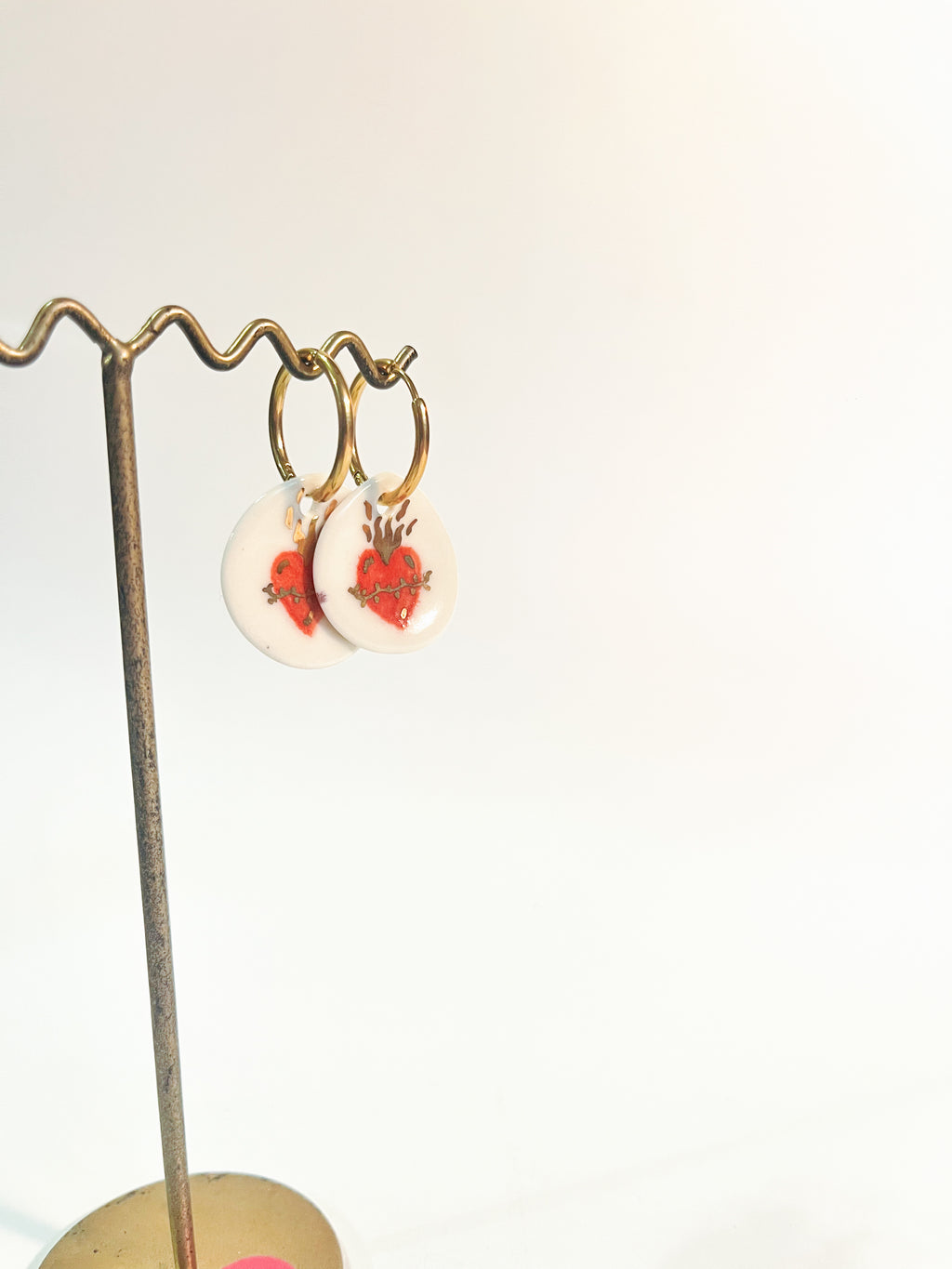 Paire de boucles d'oreilles dorées  en porcelaine blanche ronde avec un motif de cœur ex-voto rouge et de flammes d'or peint à la main 