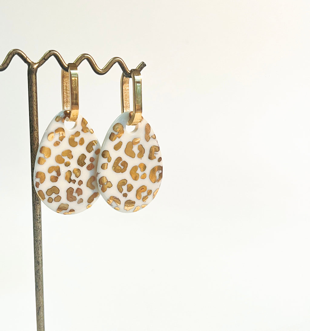 Boucles d'oreilles  allongées dorées avec médaillons en porcelaine blanche au motif animalier léopard doré.