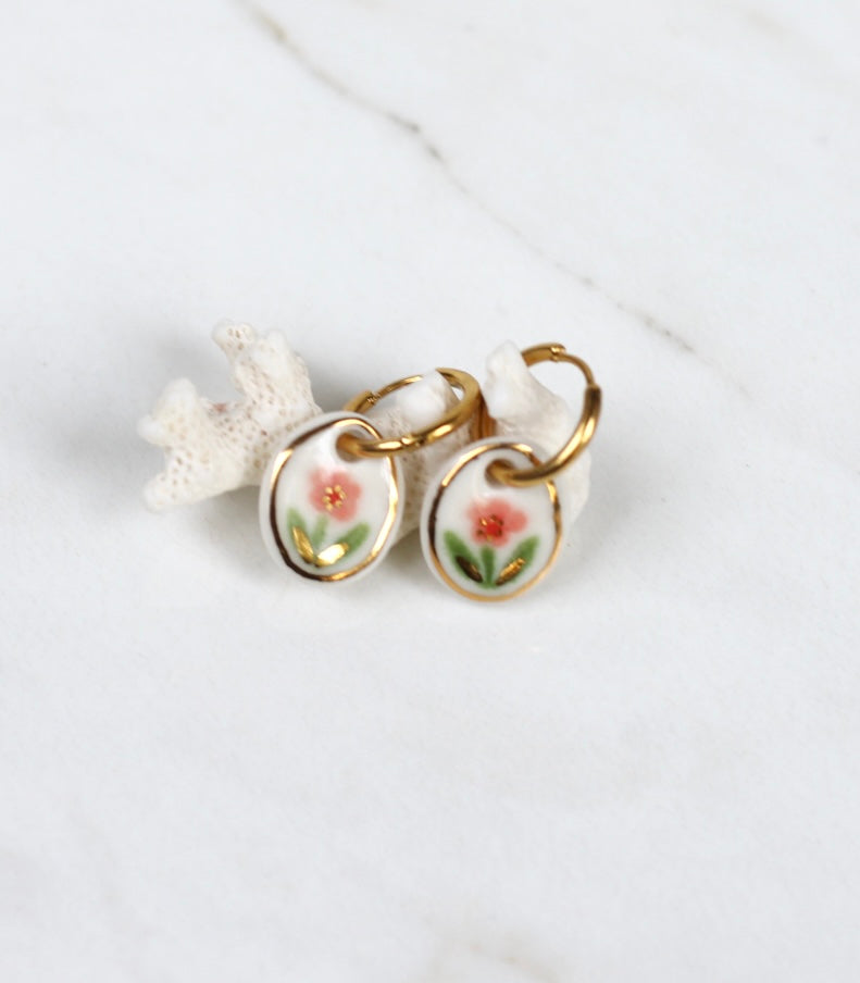 Paire de boucles d'oreilles pendantes avec petits médaillons ovales en porcelaine blanche émaillée, motif fleur rose détail d'or fin