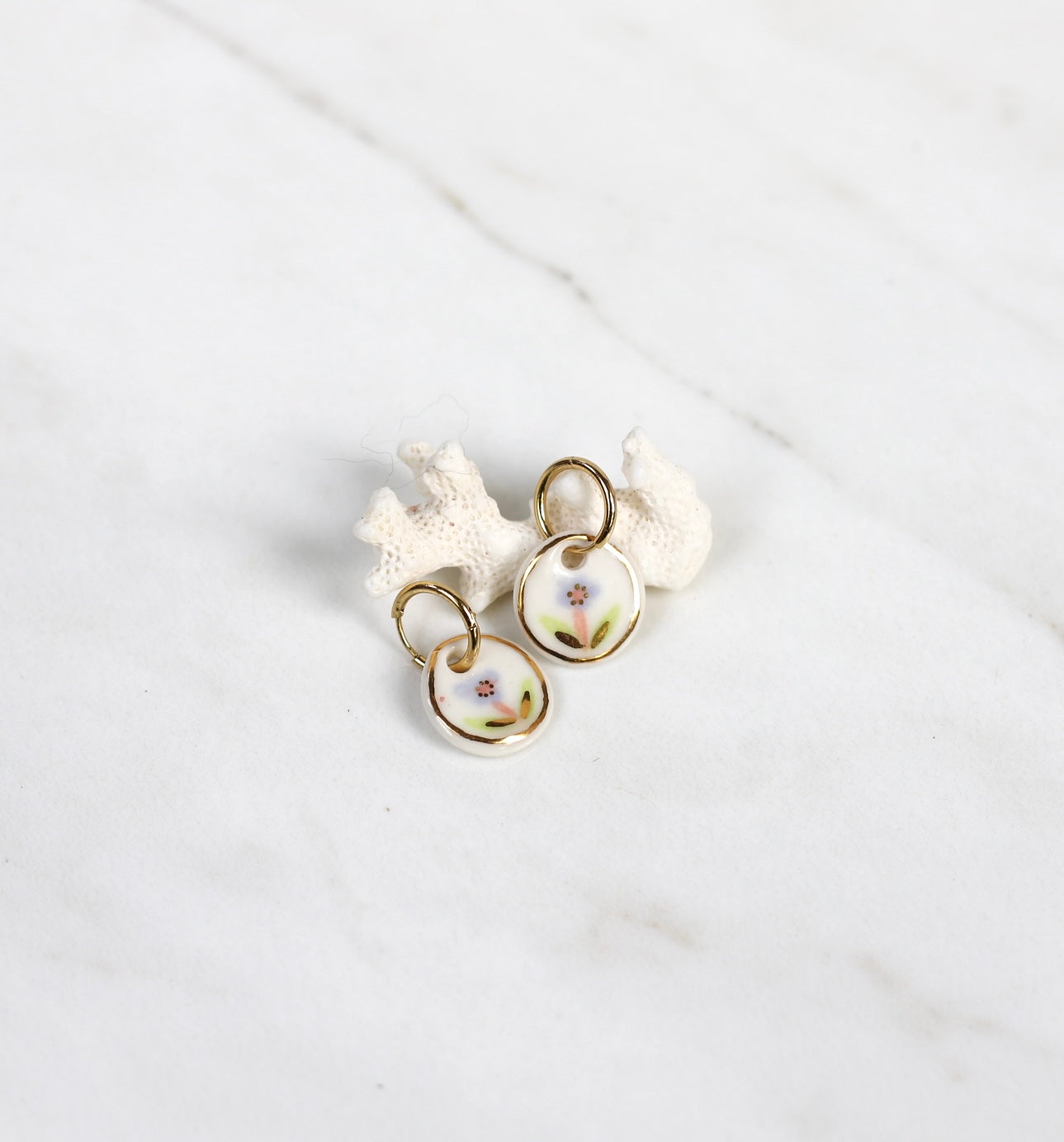 boucles d'oreilles pendantes en porcelaine blanche, avec un motif fleur mauve avec liseré d'or fin. Réalisé à la main et fait à Lyon 