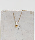 Collier fin  doté d'un pendentif en forme de goutte en porcelaine blanche dont la partie inférieure est recouverte d'or fin brillant.