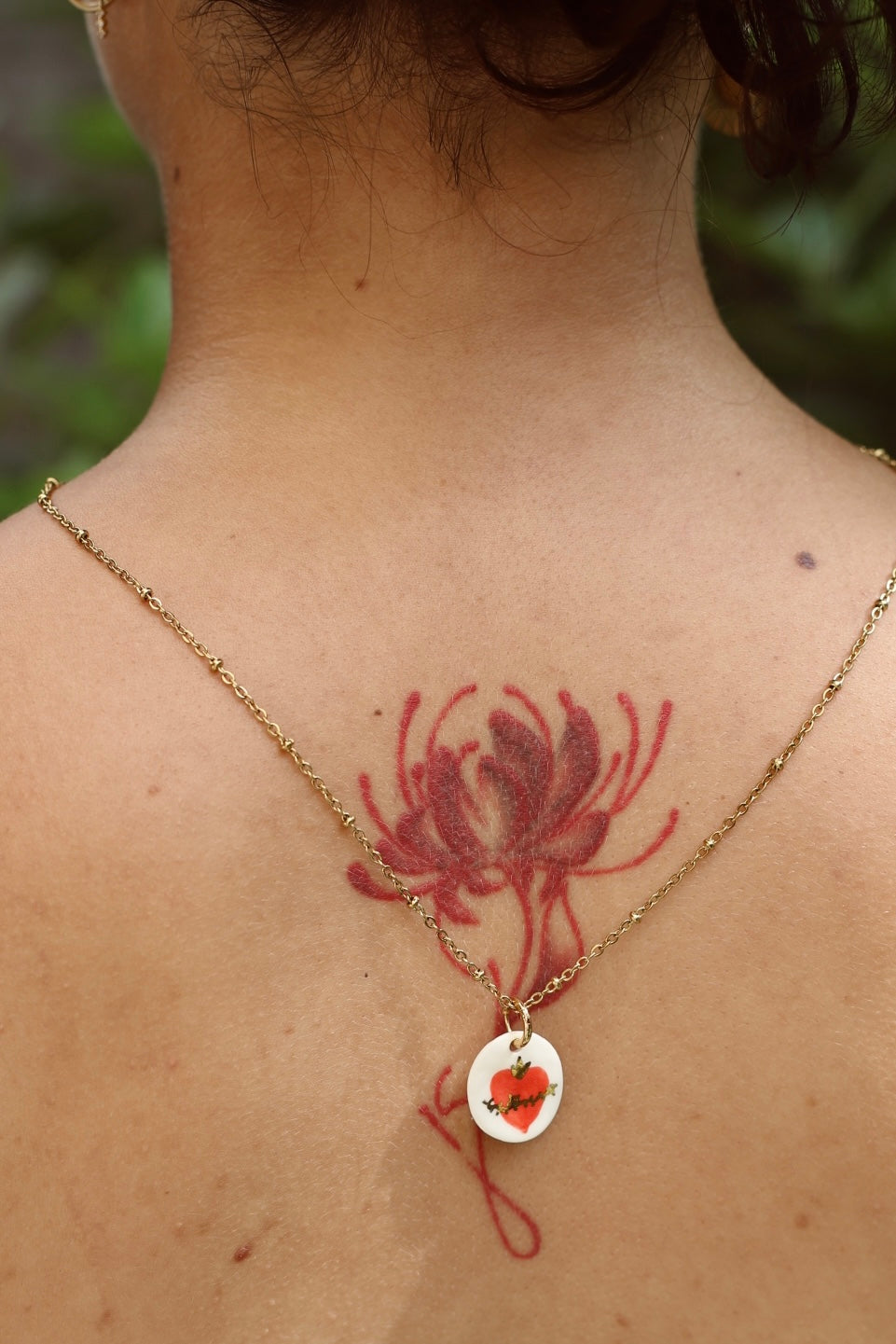 collier en porcelaine fabriqué à la main à motif sacré coeur avec des détails à l'or liquide peint à la main. 