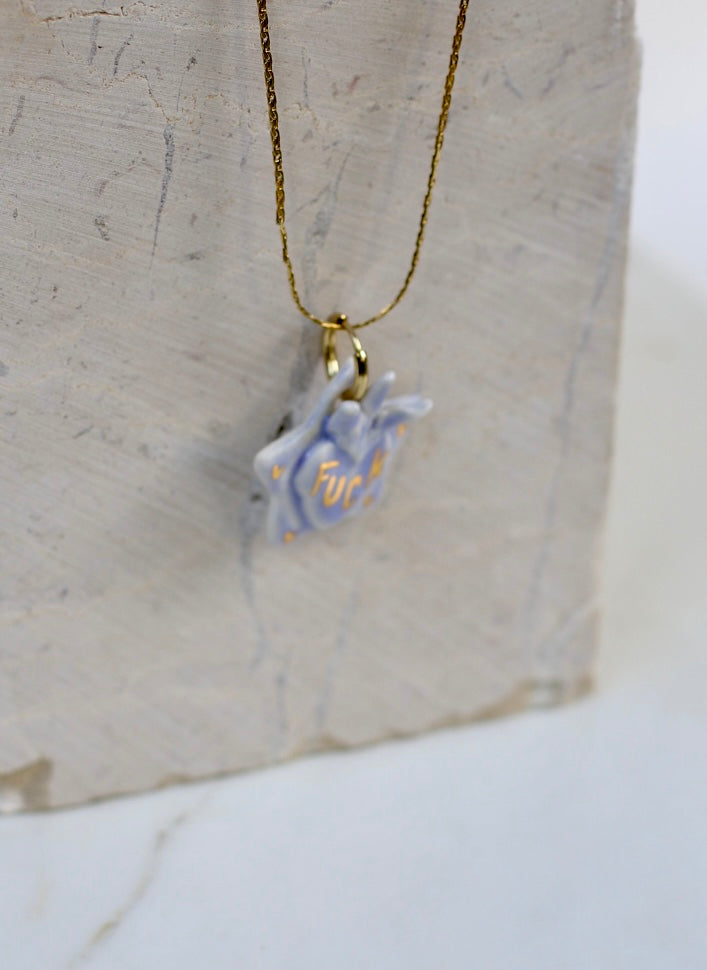 Collier en porcelaine fabriqué à la main en forme d'étoile avec un motif ex voto en relief et un inscription fuck avec des détails à l'or liquide 