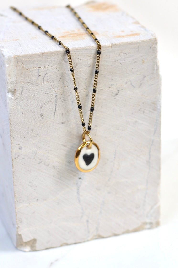 collier de créateur en porcelaine avec un motif coeur et des détails l'or liquide peint à la main 