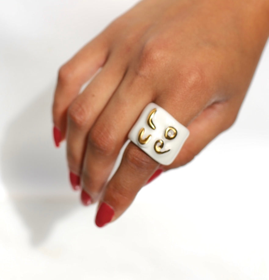 bague en porcelaine émaillée blanche en taille 59 Fr, affichant le mot 'LOVE' sculpté en relief et entièrement recouvert d'or faites à la main