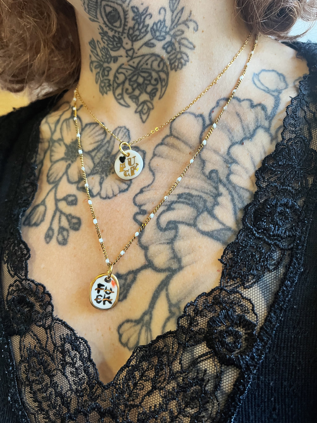 pendentif en porcelaine blanche avec inscription fuck doré, faisant partie d'un collier délicat fait à Lyon 