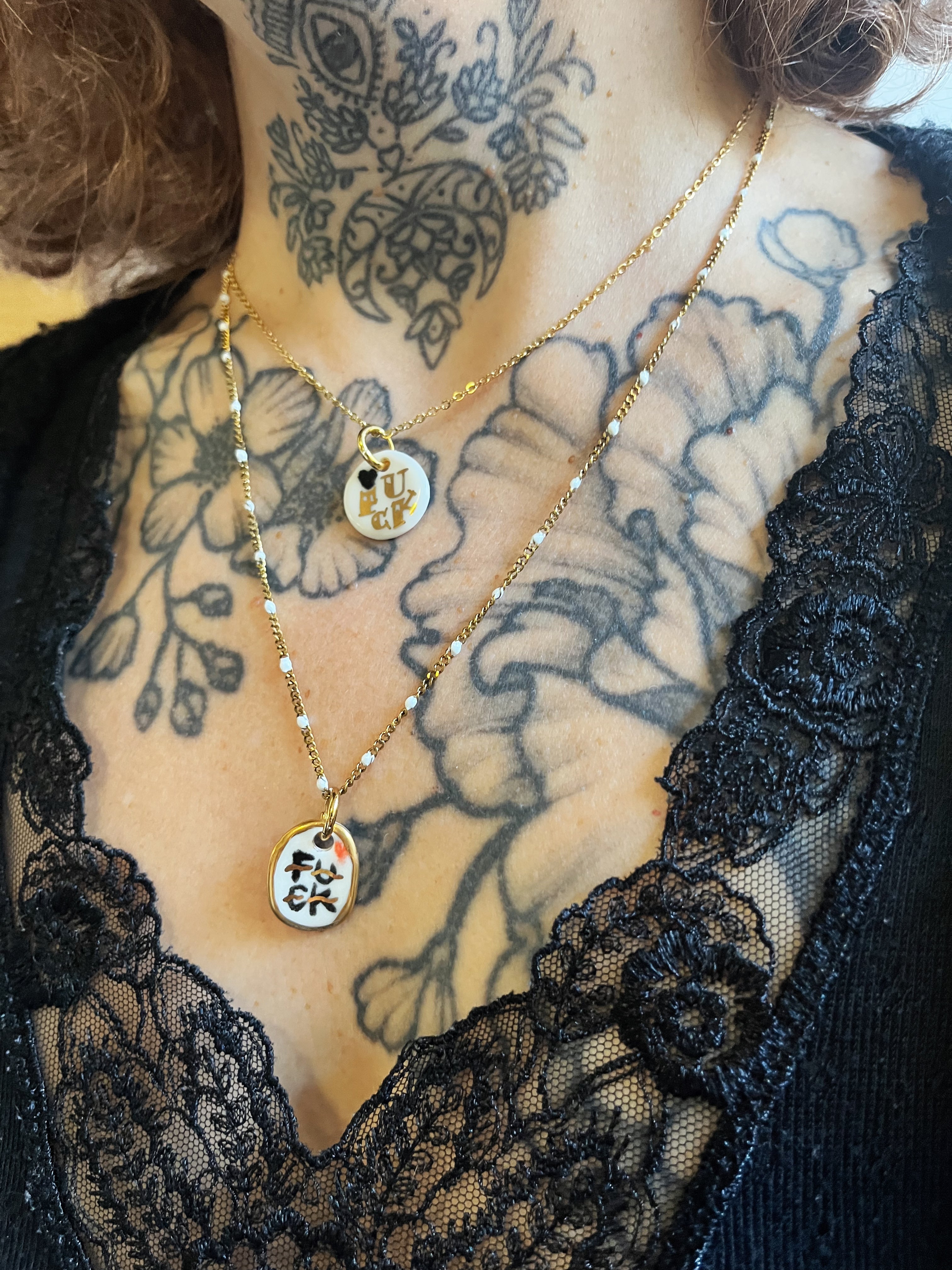 pendentif en porcelaine blanche avec inscription fuck doré, faisant partie d'un collier délicat fait à Lyon 