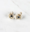 mini paire de boucles d'oreilles pendantes avec petit médaillons ronds en porcelaine blanche émaillée avec un motif cœur noir 