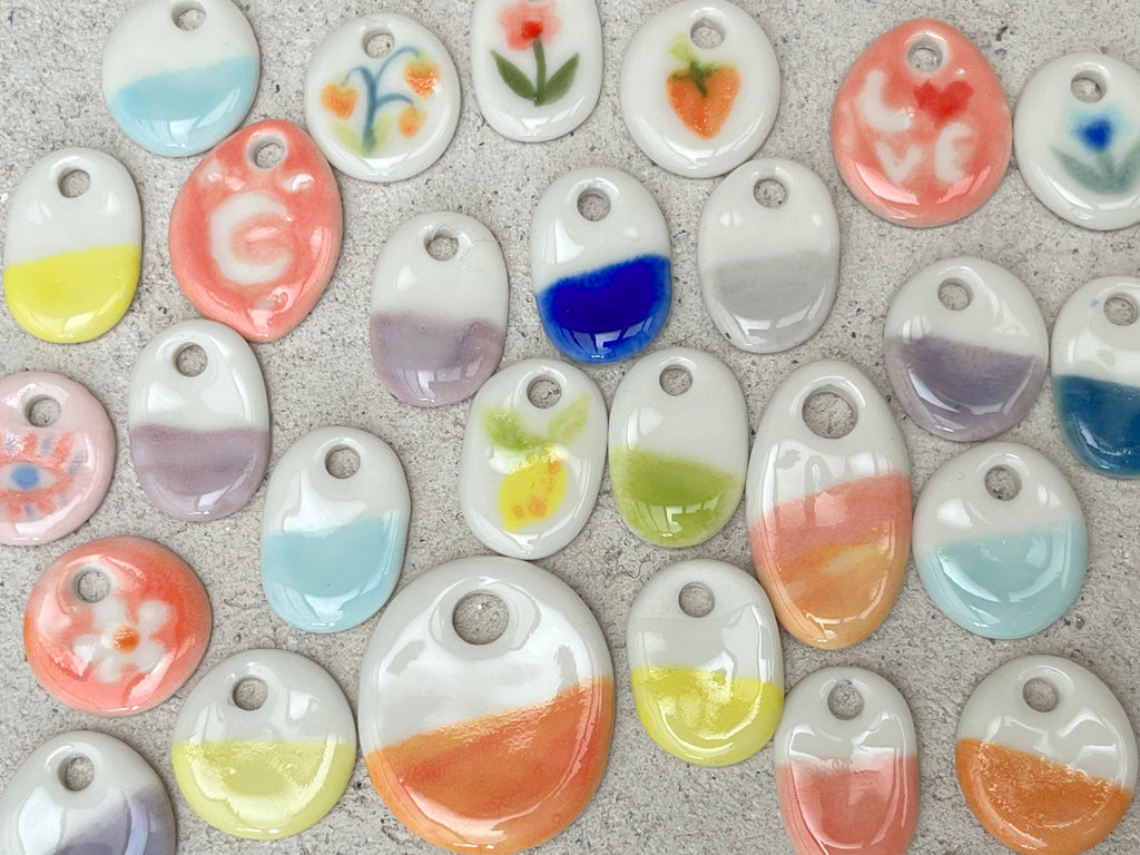 petits médaillons ronds et ovales en porcelaine façonnés à la main, teintes pastel bicolores et des motifs dorés.