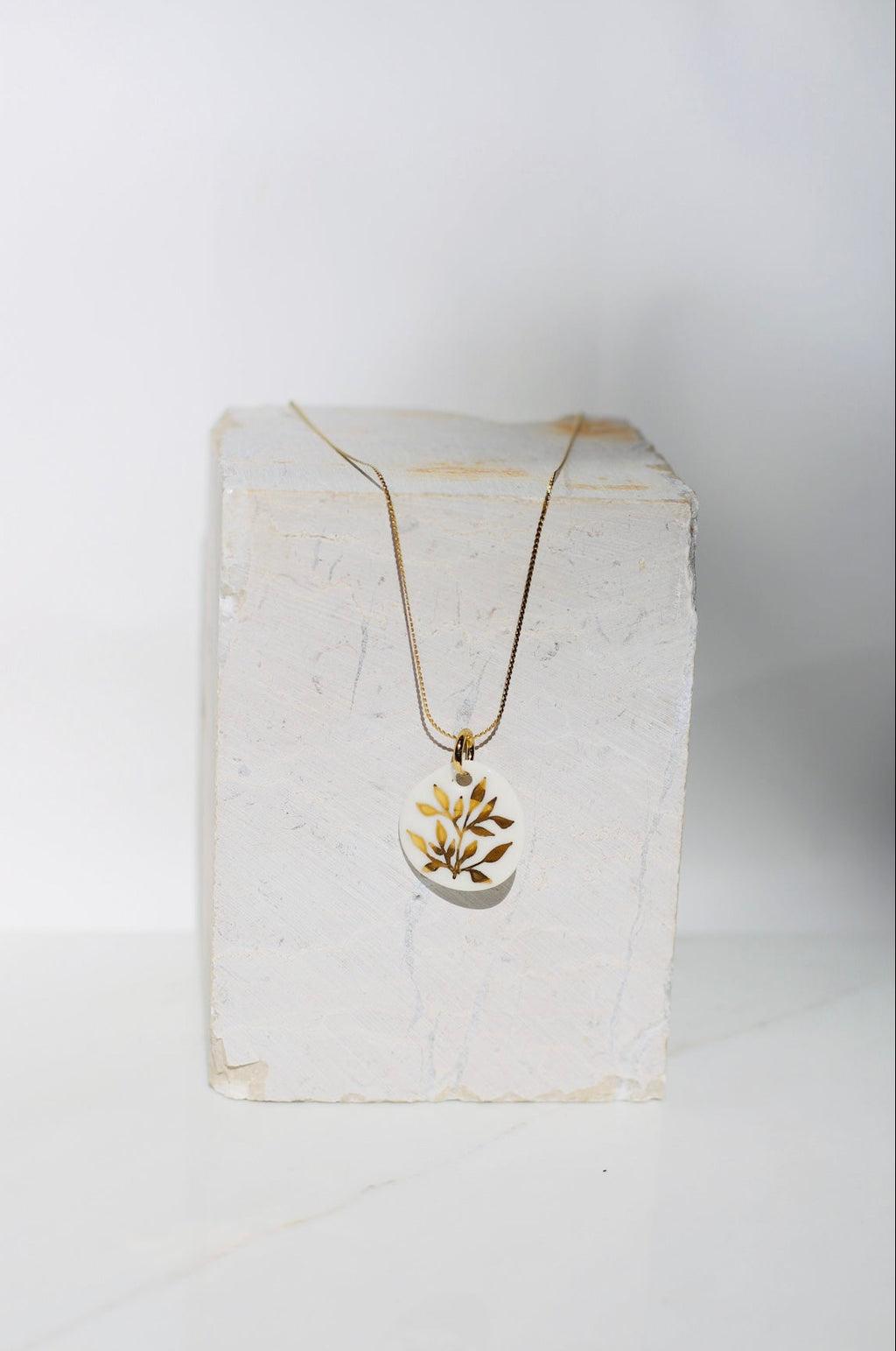 collier avec un pendentif en porcelaine fait main avec des détails floraux peint à l'or liquide 