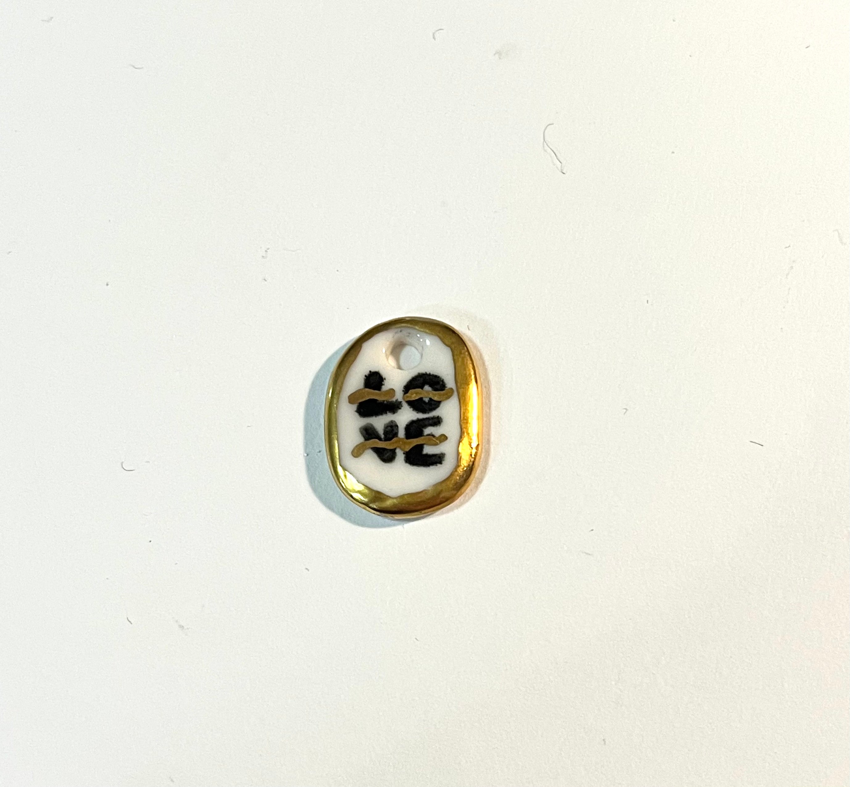 Pendentif en porcelaine love entouré d'or fais main 