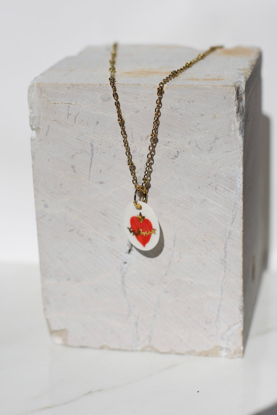 pendentif en porcelaine fait à la main avec un motif coeur enflammée avec des détails à l'or peint à la main à Lyon 