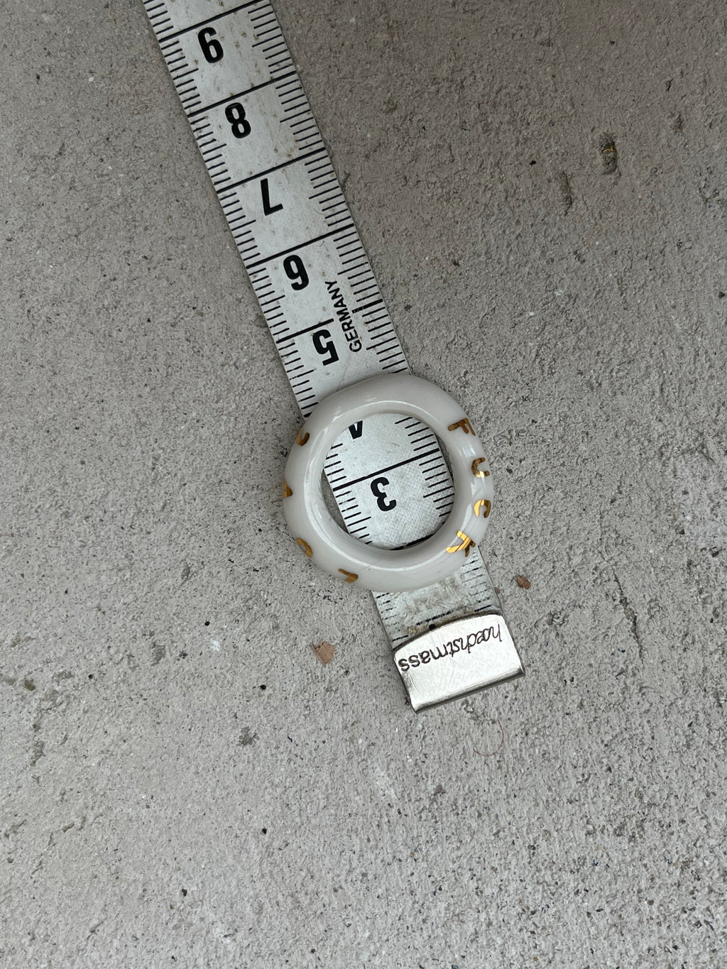 bague en porcelaine blanche émaillée en taille 55 FR, avec le mot 'LOVE' inscrit en lettres fines d'or peint à la main.