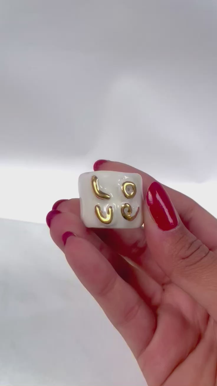 bague en porcelaine émaillée blanche en taille 59 Fr, affichant le mot 'LOVE' sculpté en relief et entièrement recouvert d'or faites à la main