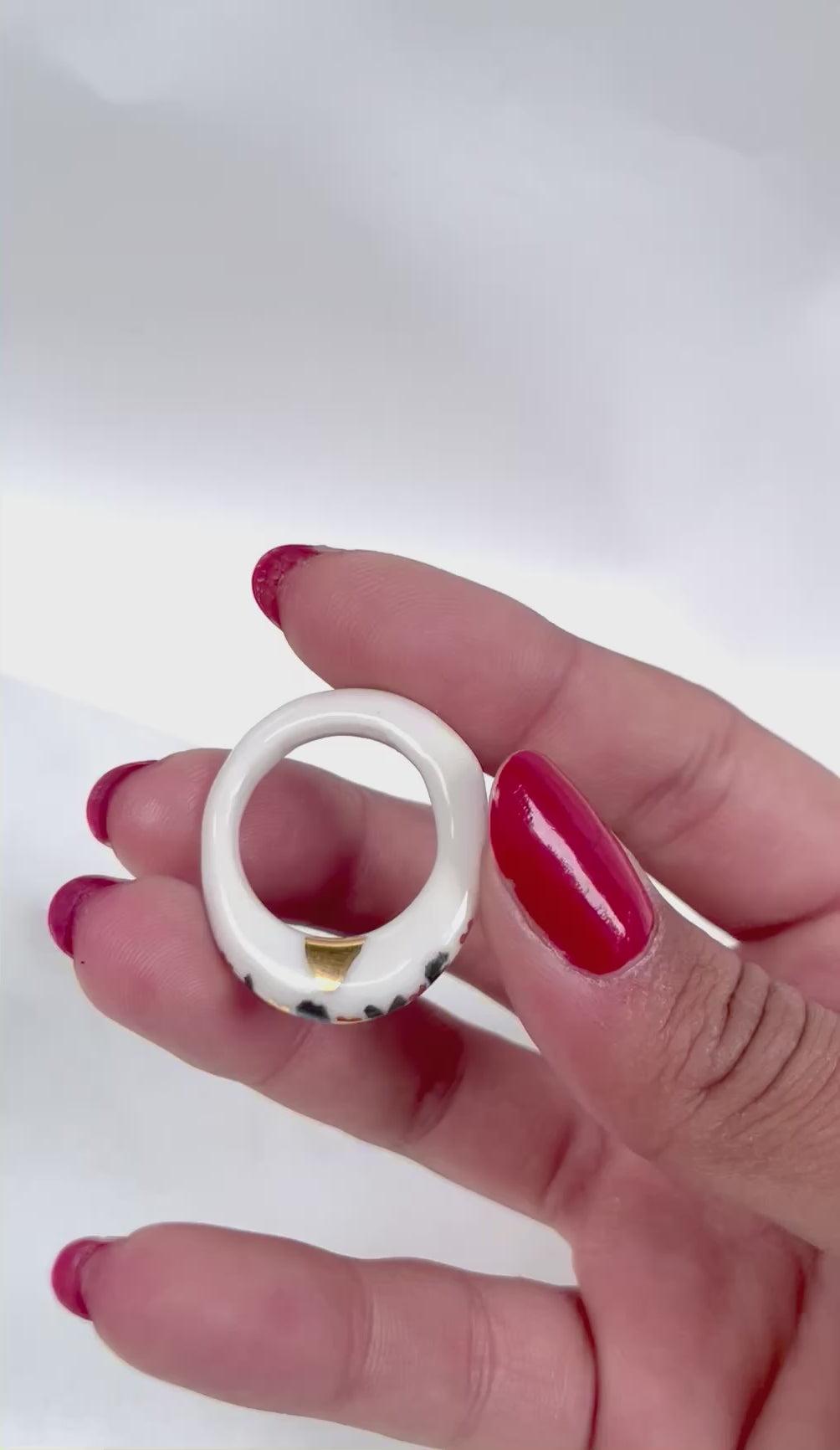 fine bague en porcelaine blanche émaillée en taille 56 FR, arborant le mot LOVE en noir peint à la main avec des détails à l'or