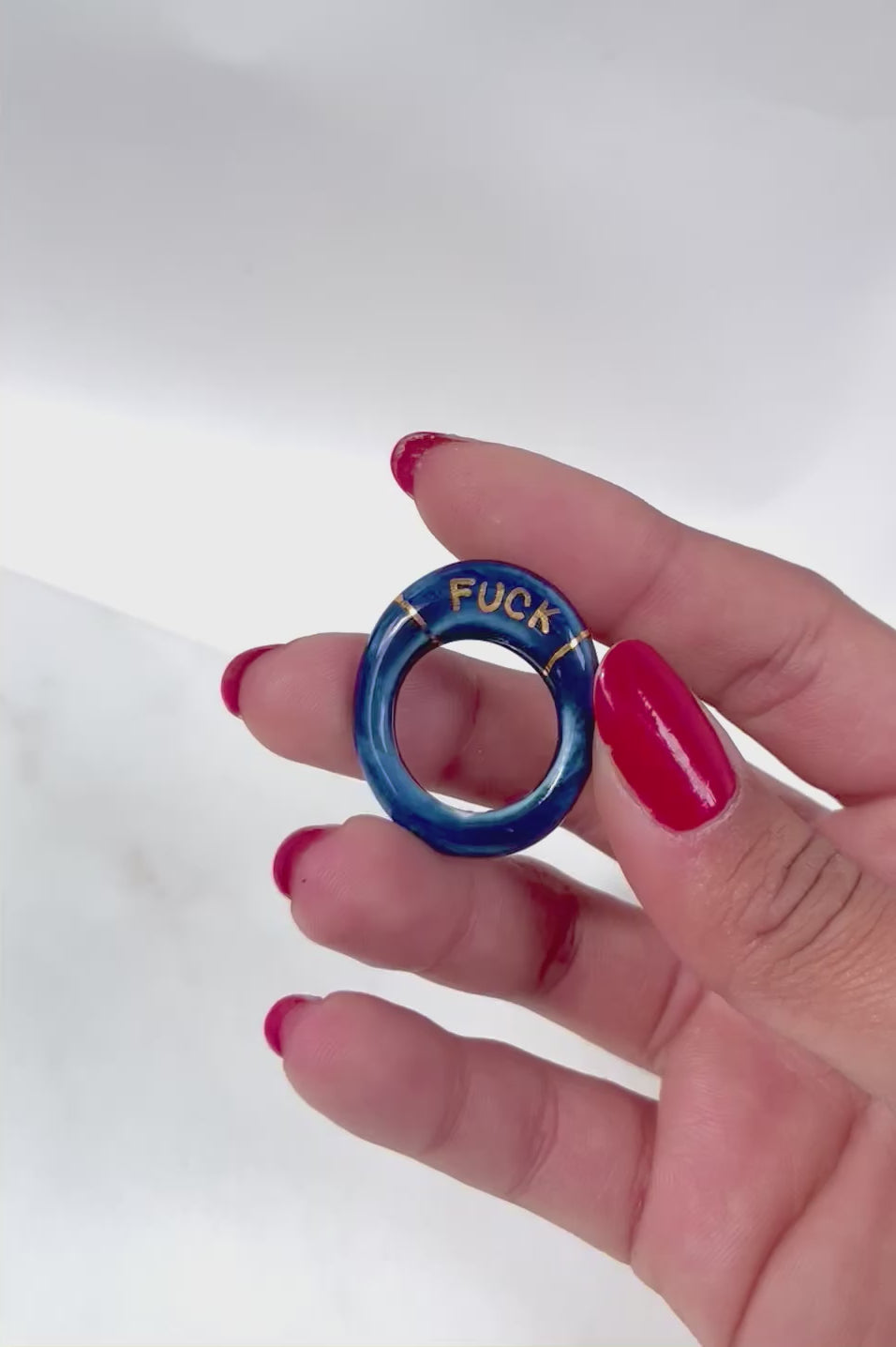 bague en porcelaine émaillée bleu nuit intense en taille 52 FR, avec fuck écrit en lettrage or peint à la main 