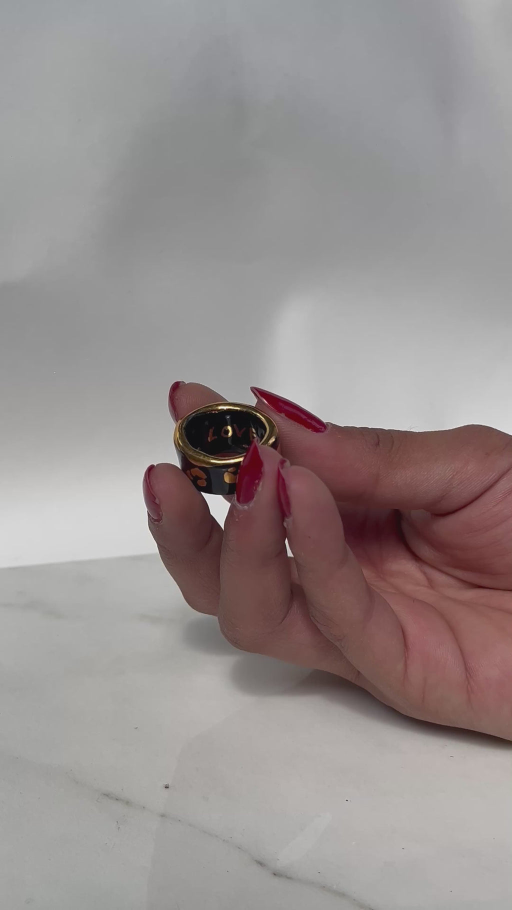 Une bague en porcelaine noir émaillée en taille 49, à motif léopards avec des tâches d'or liquide